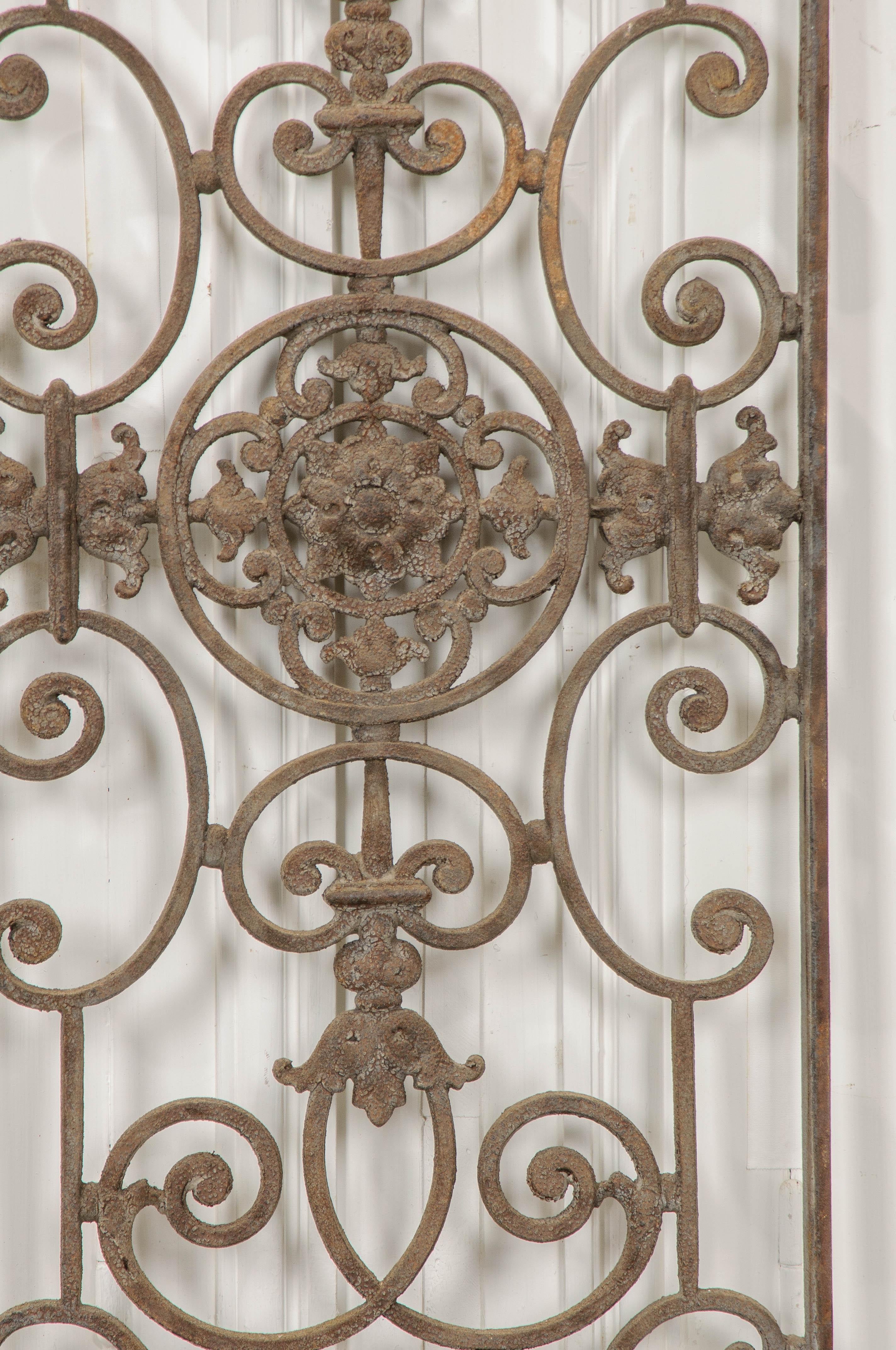 A central cruciform design of flowers and filigree is found on this wonderful wrought iron grille, made in France at the beginning of the 20th century. This decorative accent piece has acquired a wonderful patina that will bring an element of