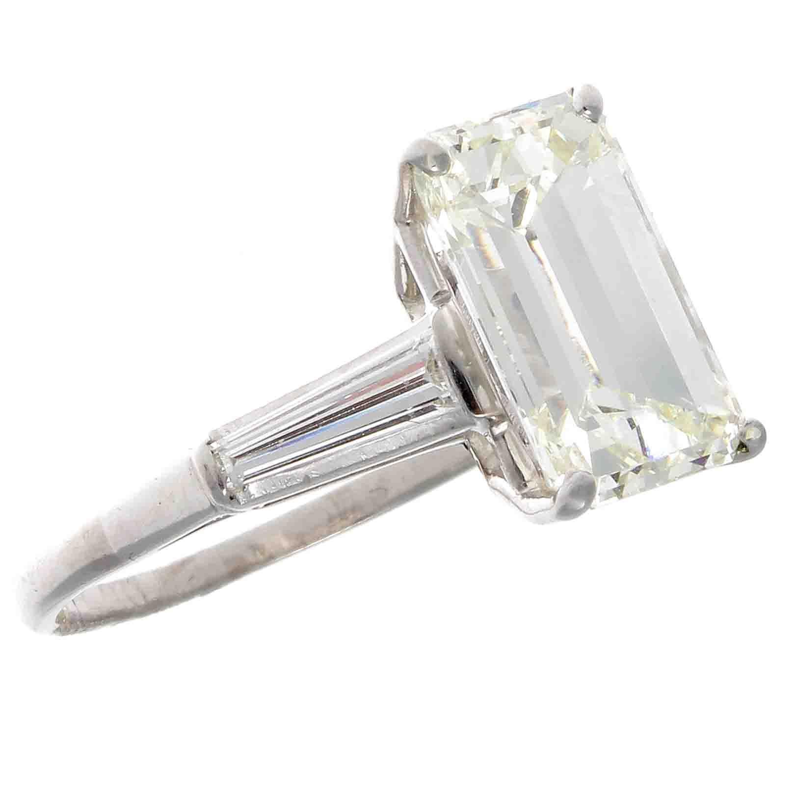 Featuring a seductively elongated emerald cut diamond that is M color, VS2 clarity. Elegantly flanked on either side by a tapered baguette which has became the customary ring of choice. Hand crafted in platinum. Stamped with French hallmarks.

Ring