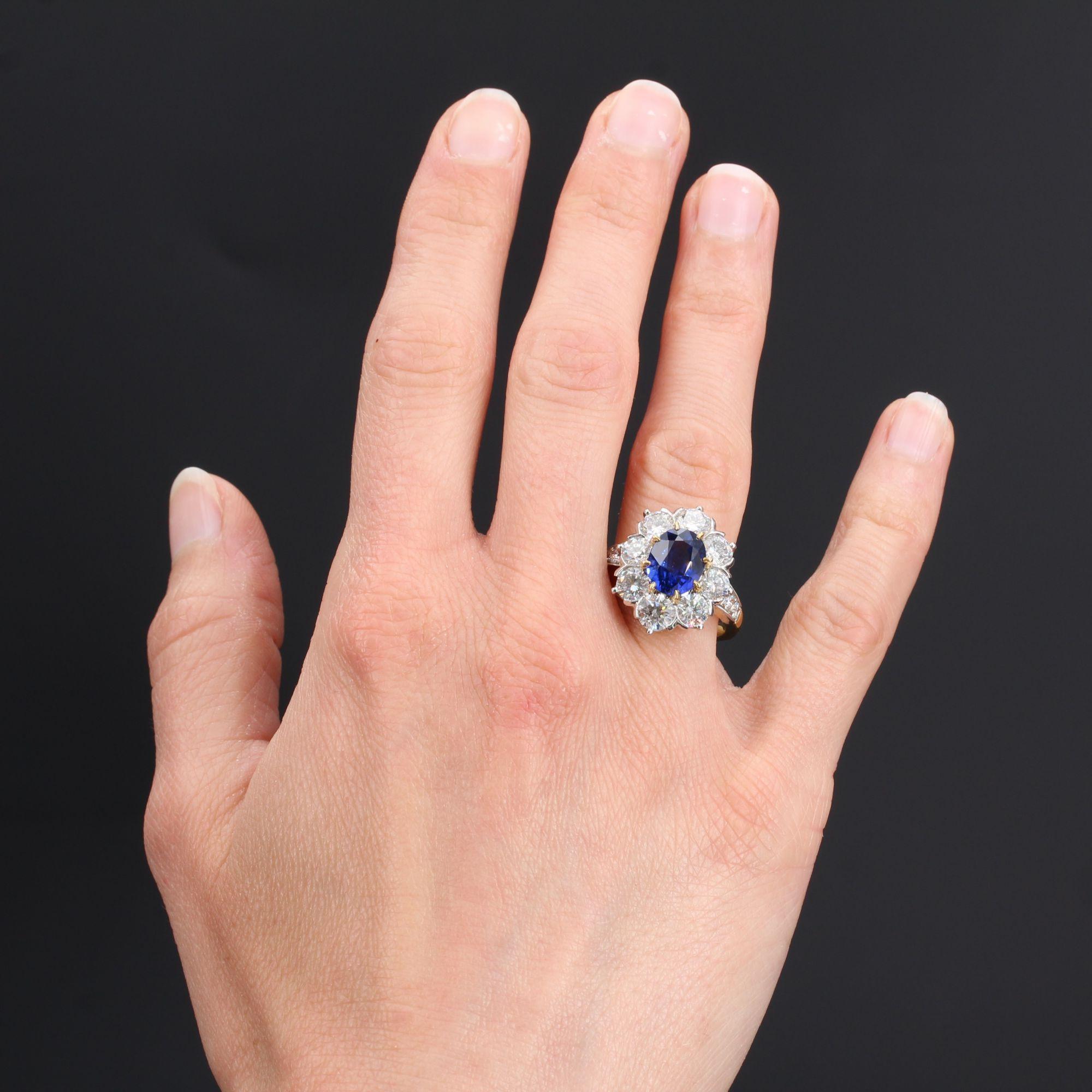 Ring in 18 karat yellow gold, eagle head hallmark and platinum, dog head hallmark.
Of oval form, this imposing ring called daisy is set in the center with 8 claws, of a blue oval sapphire, surrounded by 8 modern brilliant- cut diamonds set with