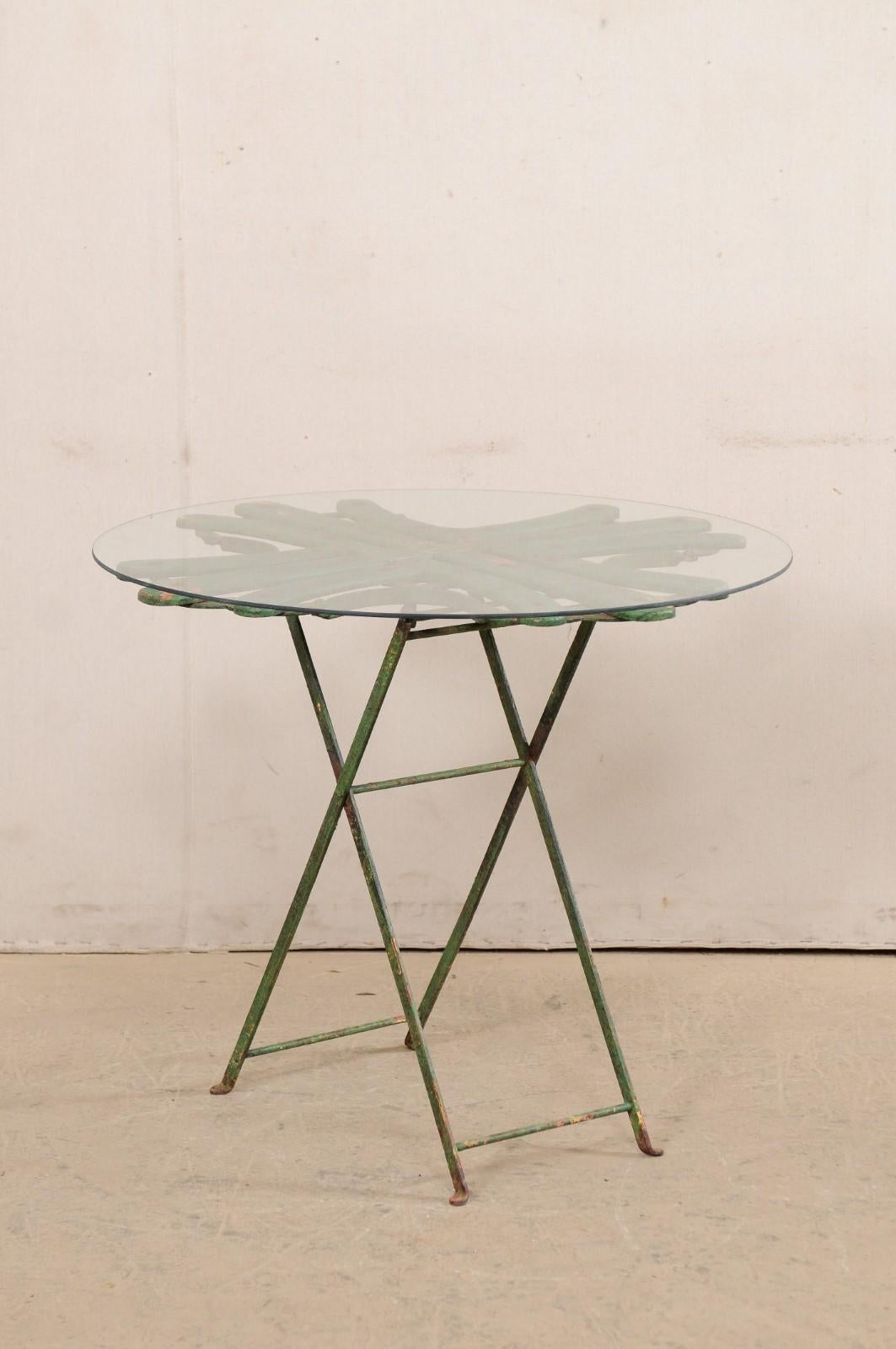 A French bistro table with a uniquely designed top from the mid 20th century. This vintage table from France features an unusual wood top, with a geometrical pattern of three lines intersecting three additional lines, in perpendicular fashion to one