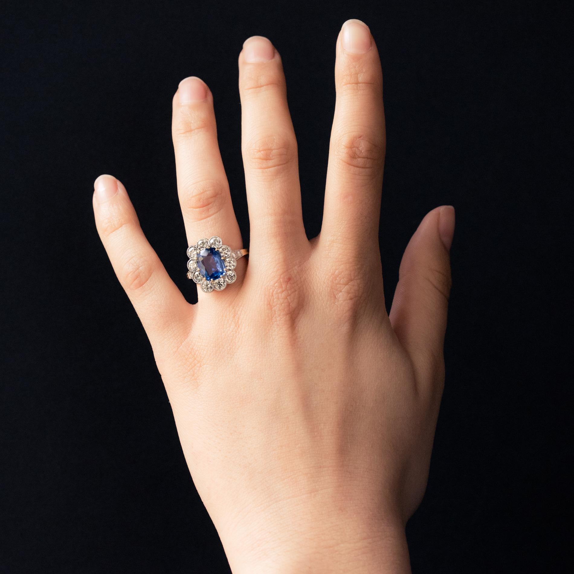 Ring in 18 karat yellow gold, eagle's head hallmark and platinum, dog's head hallmark.
Sublime daisy ring, its setting is adorned with a rectangular cushion- cut blue sapphire set with claws,  surrounded by 10 modern brilliant-cut diamonds. On both