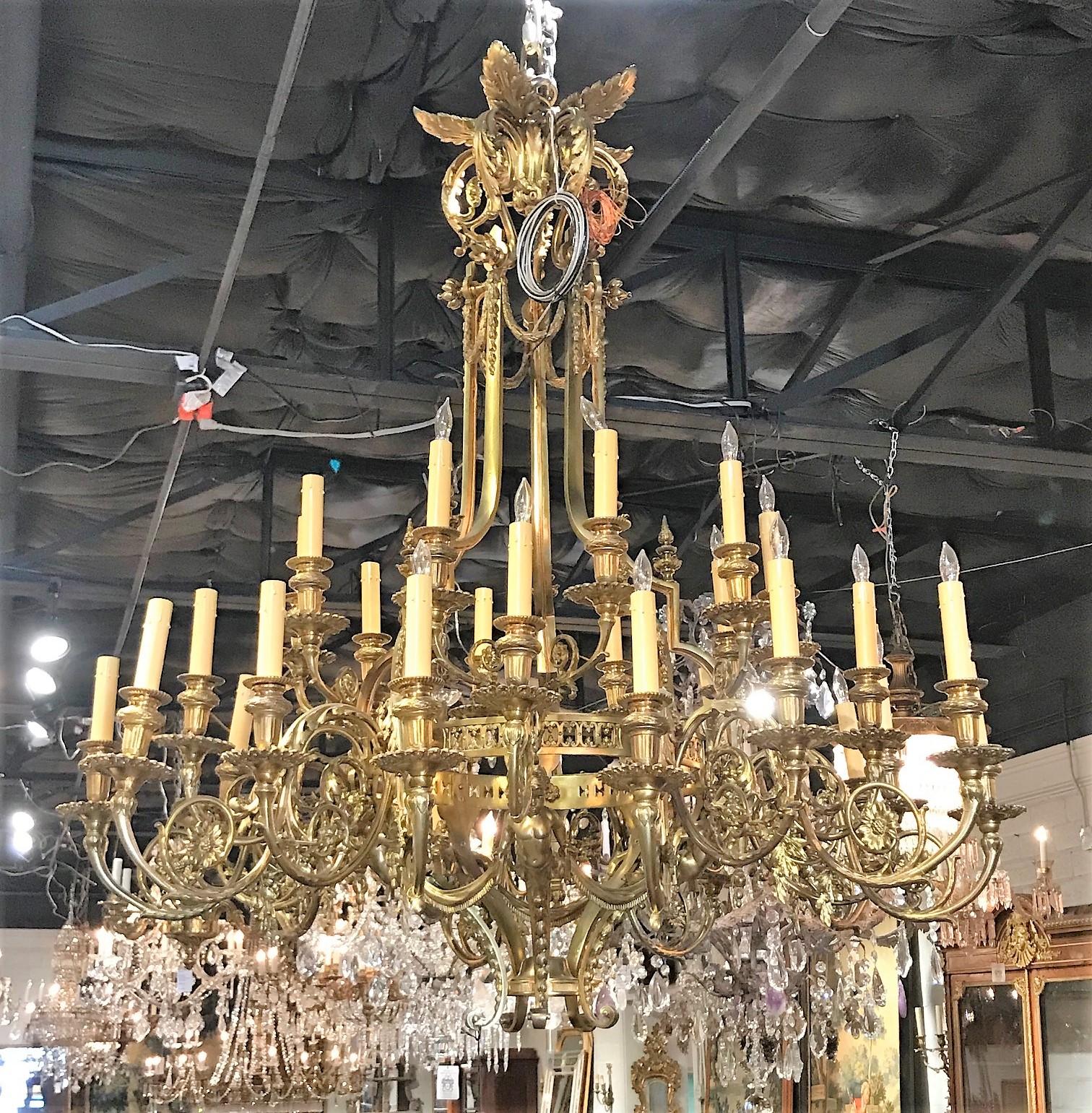 Remarkable large French 36-light gilt bronze cherubic chandelier of superior quality. The ornately decorated crown with leaf-sprays atop elaborately scrolled arms adorned with acanthus leaves, flower heads, and cast bronze cherubs holding fringed