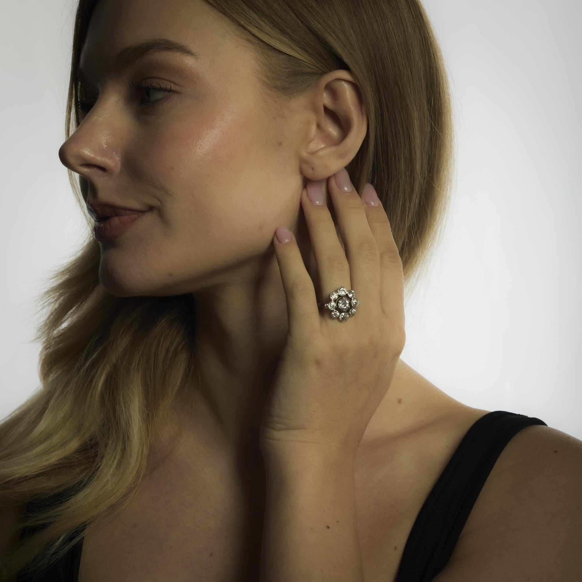 This Mid Century French ring radiates timeless brilliance with an .80 carat old European cut diamond framed by 3.20 carats of sparkling old European accents in luminous 18k white gold.