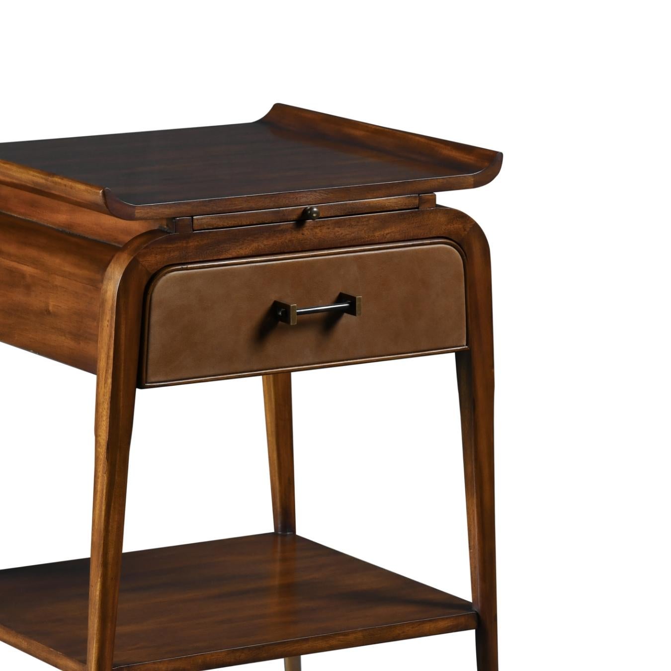 This night stand is inspired on the French 50’s with a hint of oriental influences. Its top has upwardly curved ends, a retractable table, leather covered drawer and finely pointed legs with brass caps. It also has a wide lower shelf, making this