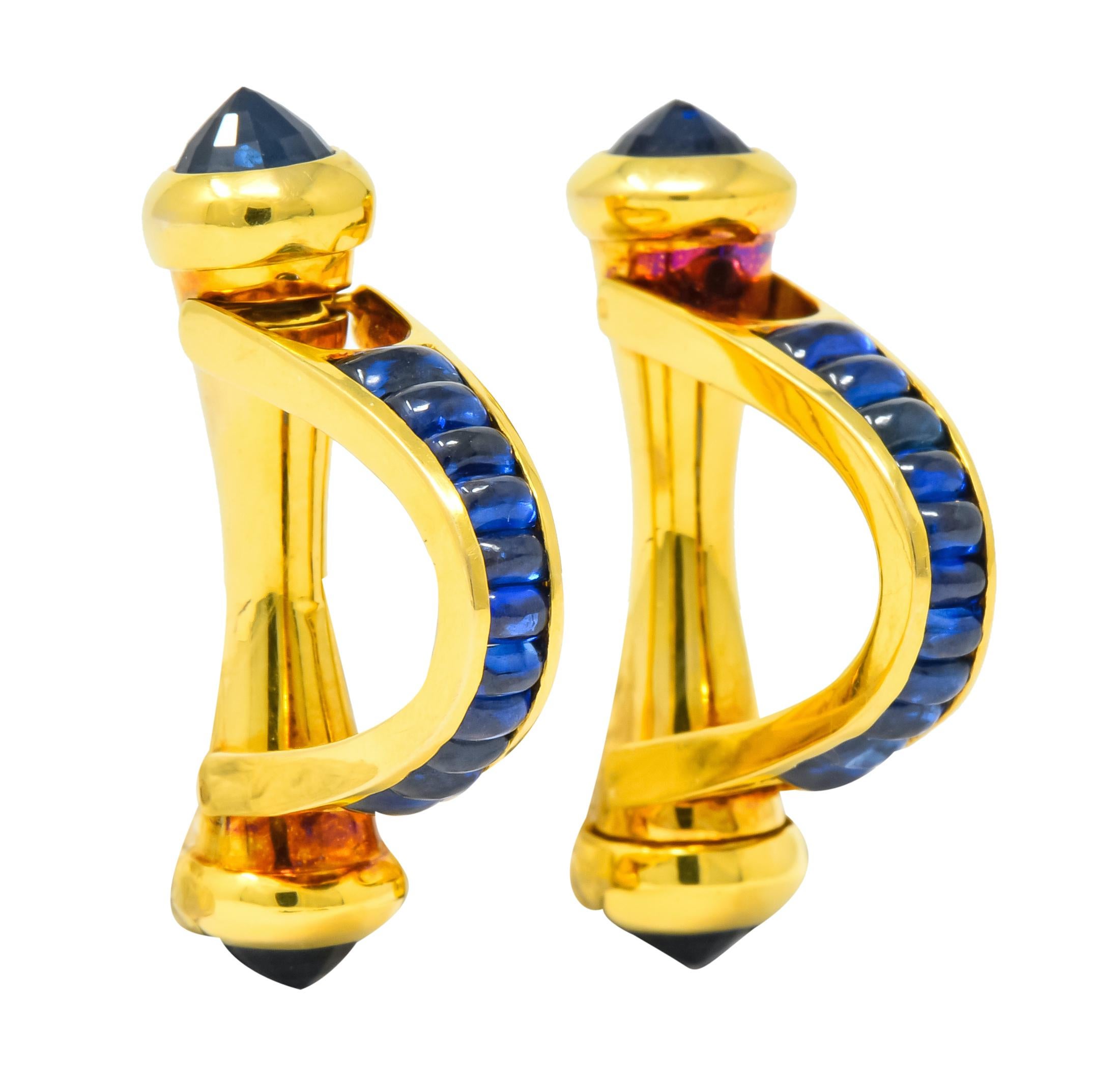 Around-the-cuff style cufflinks with a hinged, spring loaded closure that terminates in mixed cut reverse set sapphires

With cushion cabochon sapphires, graduating in size, channel set in polished gold

Sapphires are a very well matched royal blue