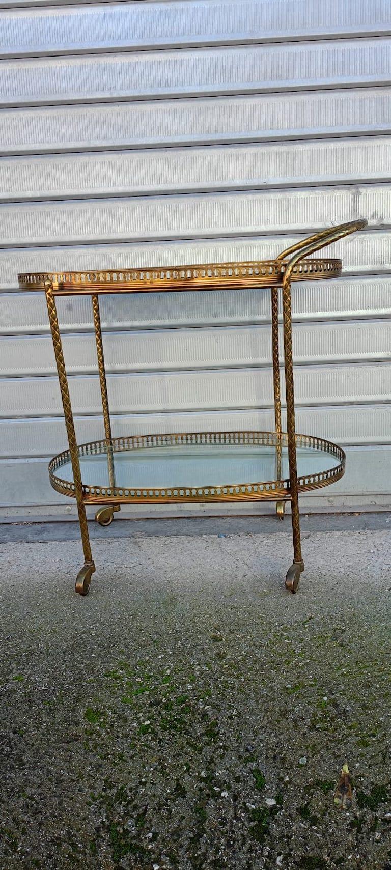 Un élégant chariot de bar ou trolley ovale en laiton constitue la table d'appoint idéale pour votre intérieur. Ce chariot de bar à deux niveaux présente deux surfaces vitrées ovales entourées de galeries percées. Français c.I.C. Attribué à Maison