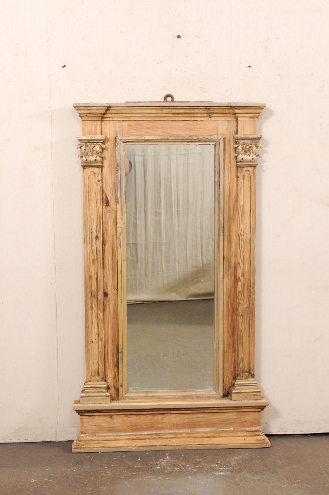 Un alto specchio francese con accenti architettonici della fine del XIX secolo. Questo specchio antico proveniente dalla Francia presenta uno specchio di forma rettangolare al centro, incorniciato da una cornice esterna che è affiancata da entrambi