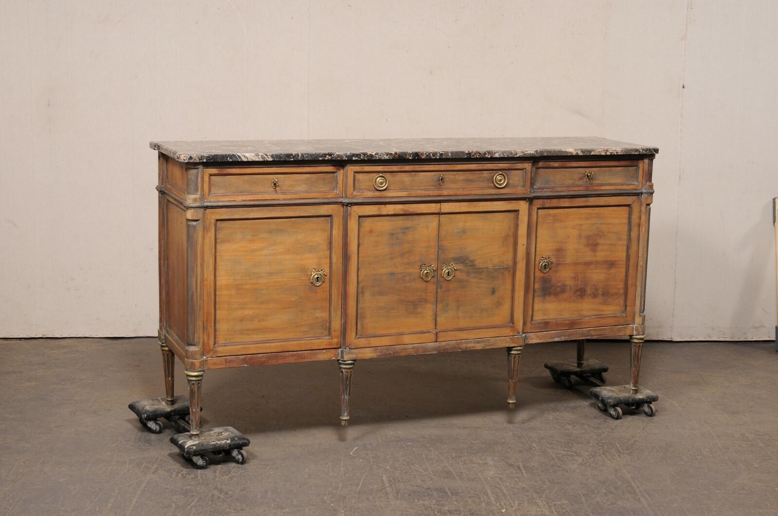 A French carved wood sideboard, with Neoclassic accents and marble top, from the mid 20th century. This mid-century buffet console from France has a shallow break-front design with profiled corners that carry through from its marble top to body. The