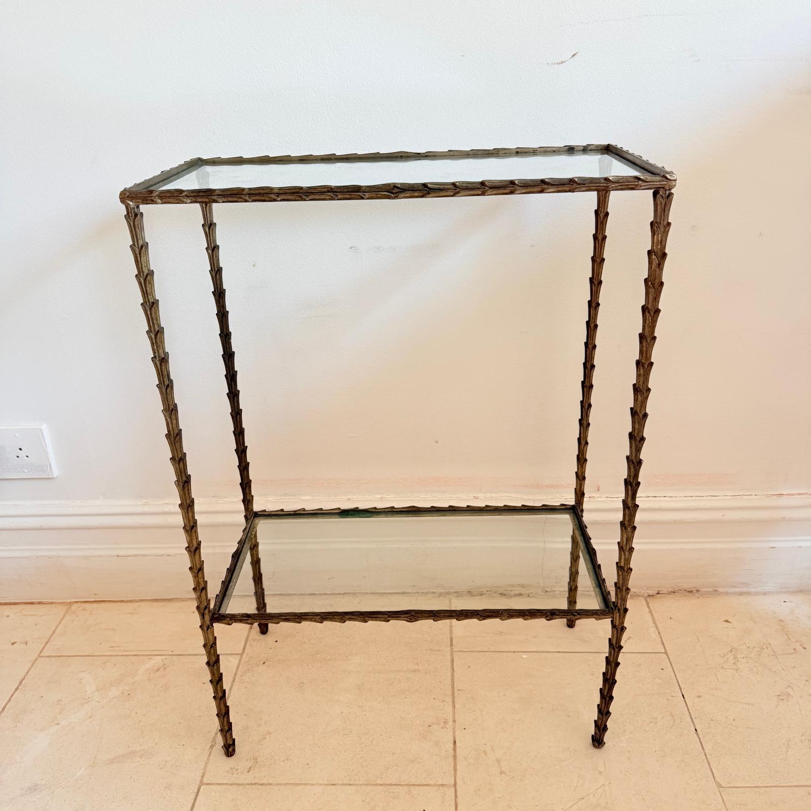 This beautiful two-tier console table by French house Maison Baguès was created in the early 1960s with solid foliage shaped brass structure and a two tier shelves in glass
