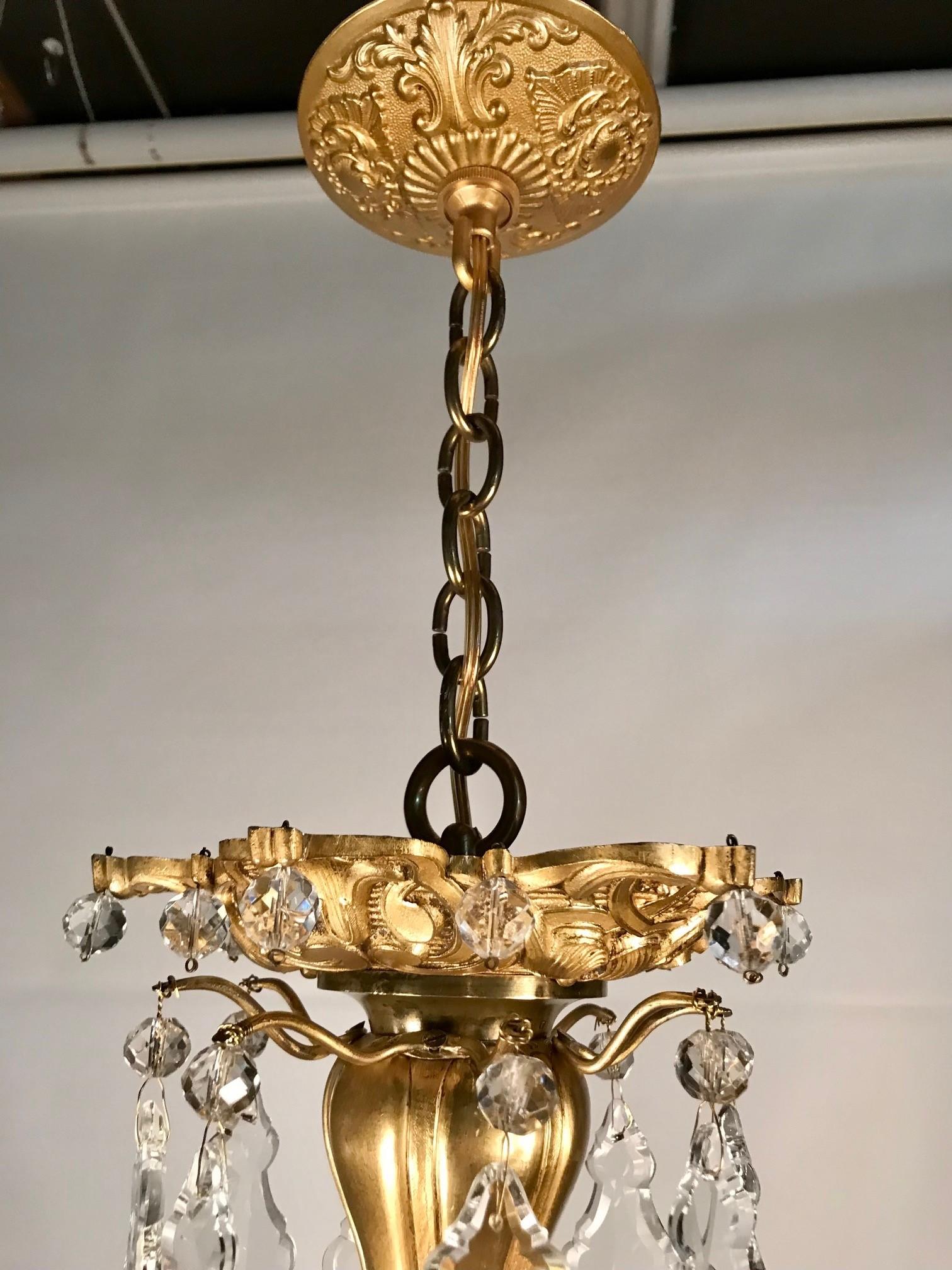 Early 20th Century French 8 Light Bronze Chandelier Hung with Crystal Drops For Sale