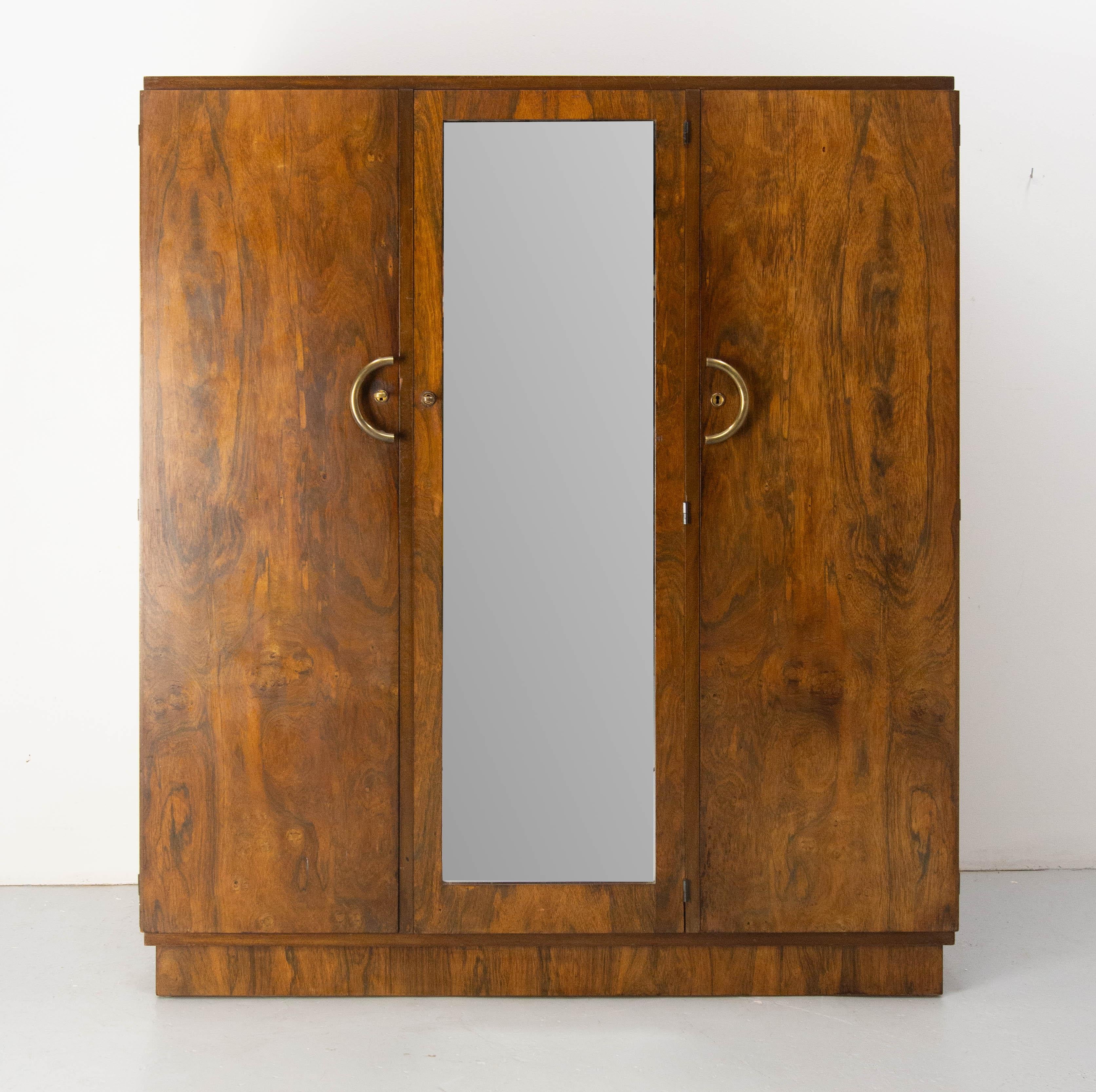French three doors cabinet. A bevelled mirror on the central door.
Mahogany veneer and brass. 11 drawers in the two part sides. Two of the little drawers can be locked.

Made circa 1930.
Good condition with some marks of use, not disturbing (please