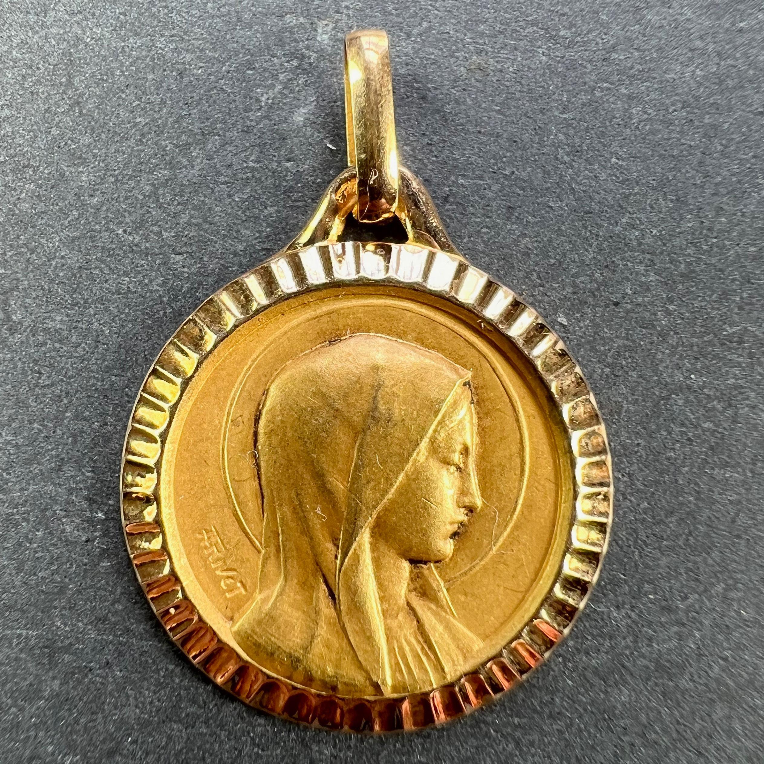 A French 18 karat (18K) yellow gold pendant designed as a round medal depicting the Virgin Mary within a halo, with a polished ridged frame. Signed A Rivet. Stamped with the eagle’s head for French manufacture and 18 karat gold, with a trace of an