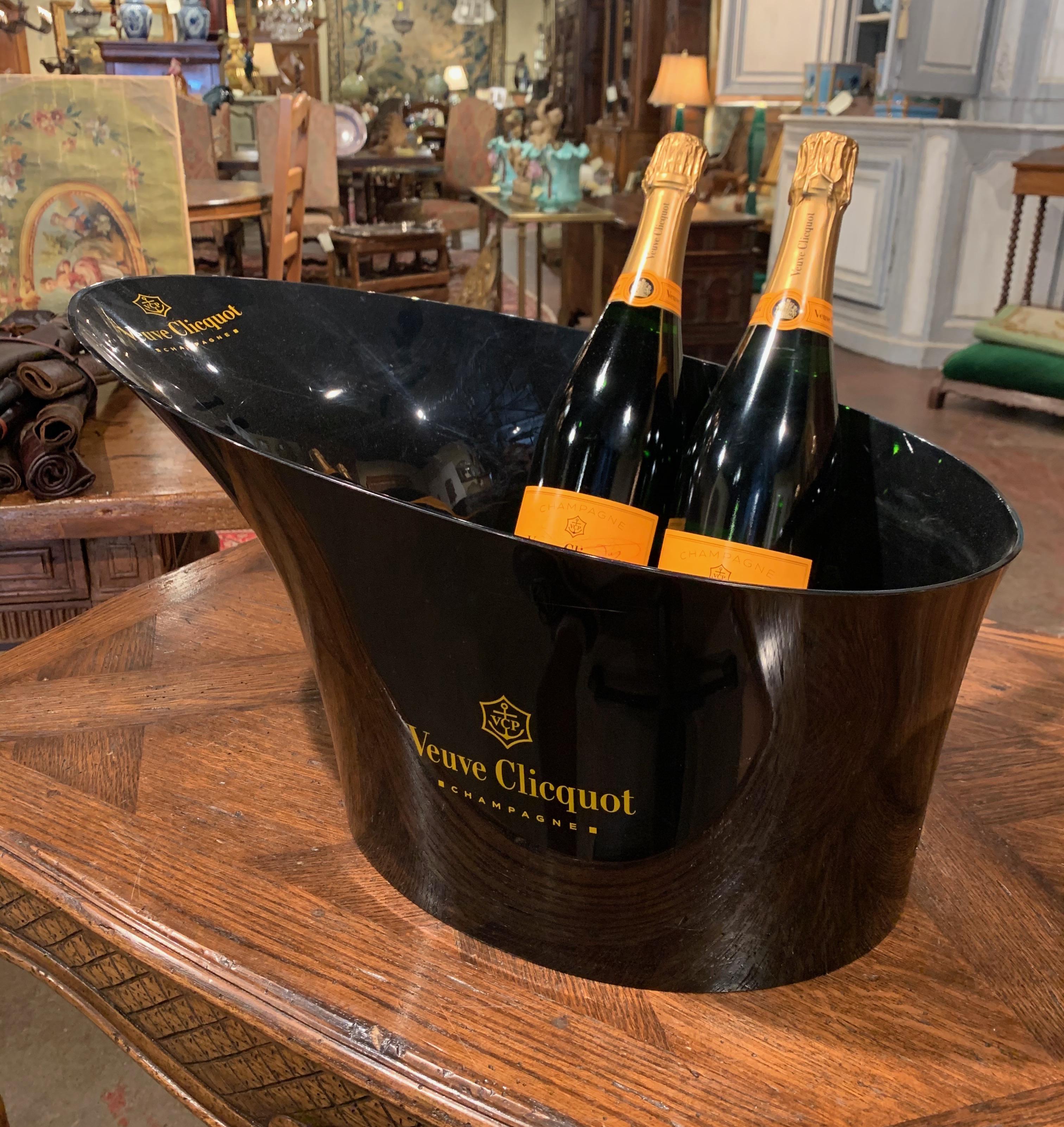 Décorez un bar humide avec cet élégant seau à champagne magnum et deux verres assortis. Fabriqué en France vers 1980 et en plastique dur, le seau vintage provient de la maison emblématique Veuve Clicquot. Le seau noir est en excellent état et peut