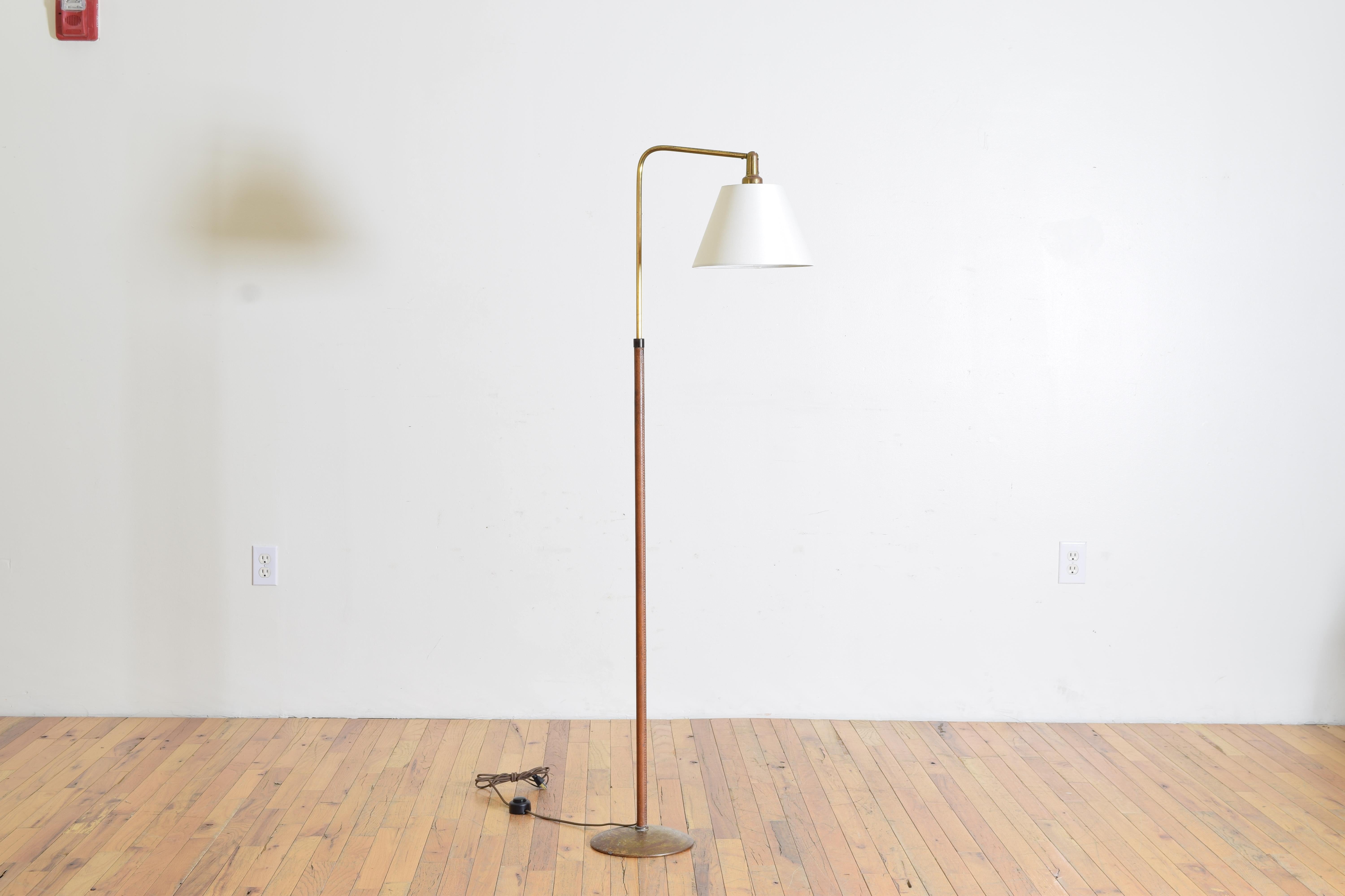 French reading lamp in the style of Jacque Adnet, newly rewired, the leather having a faint texture and top stitching with a brass arm and base.  Height lowers to 59