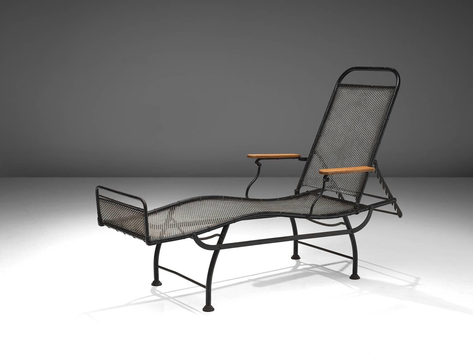 Daybed, black coated iron, wood, France, 1930s.

The back of this daybed is fully adjustable and has some well worked out details in the iron works. The blond wooden armrests provide both an aesthetic and functional contrast to the black coated