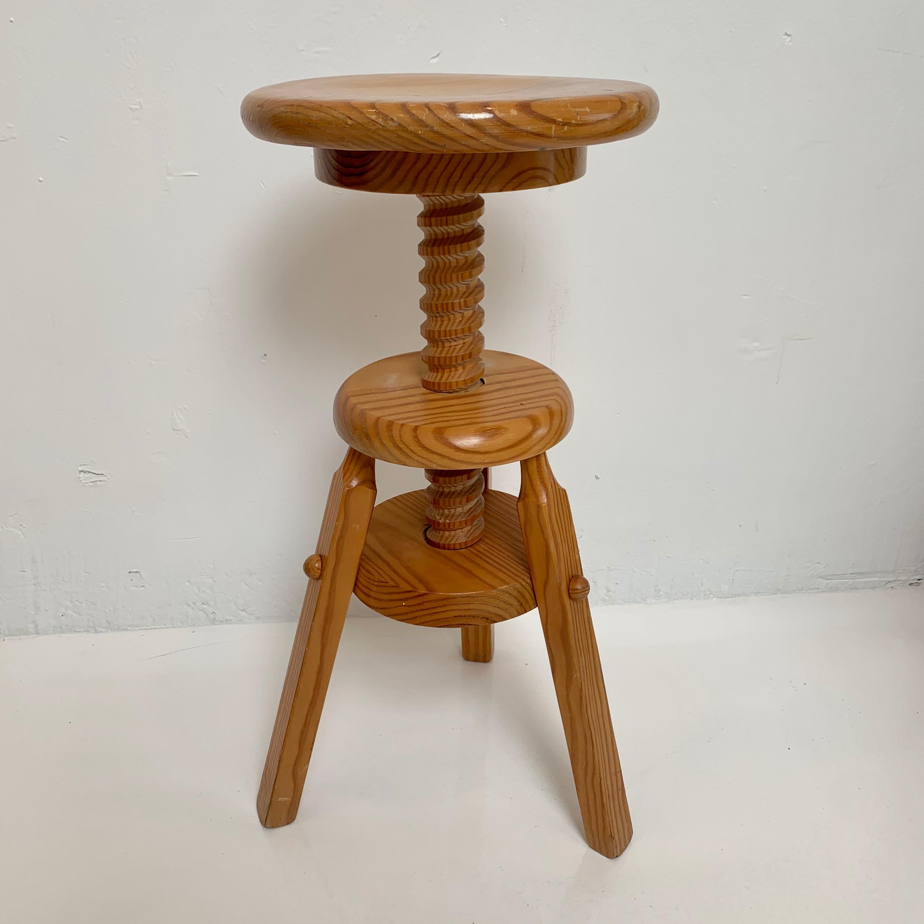 Artistic pine stool made entirely of wood. Large wood screw attached to seat allows the stool to change heights with a quick spin. Great for the piano, show casing art or a standalone seat. Good vintage condition. Measures: Height adjusts from