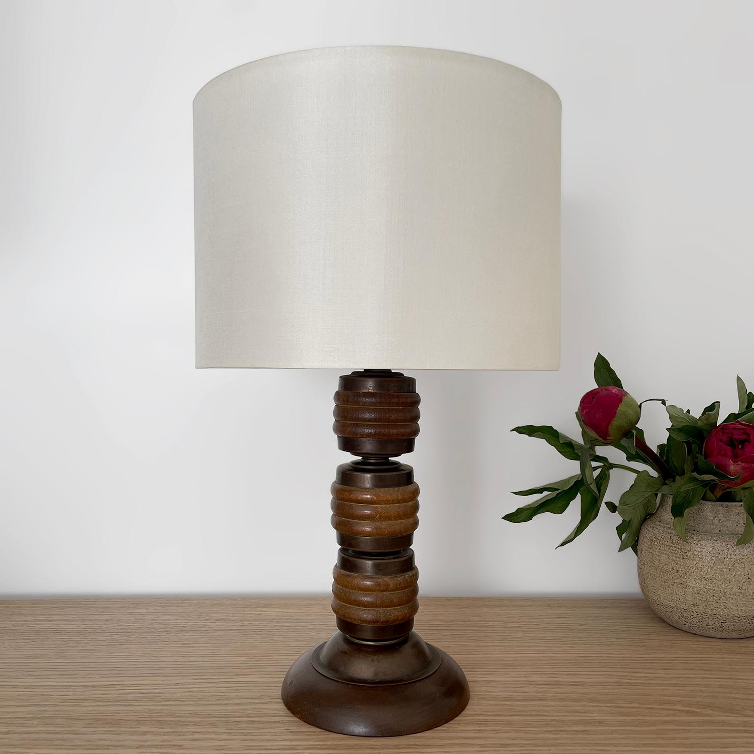 Lampe à poser en bois et laiton vieilli
France, milieu du siècle
Pièce artisanale fabriquée à la main 
La source lumineuse unique est entourée d'une coupelle en laiton vieilli magnifiquement sculptée. 
La tige de la lampe est fabriquée en bois