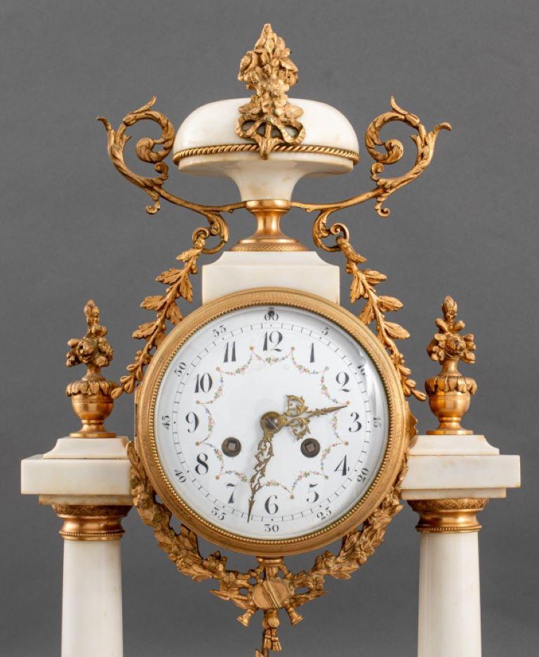 French Alabaster and Gilt Brass Portico Mantel Clock with porcelain clock face.  Provenance: From a 50 Madison Avenue estate. 

Dealer: S138XX