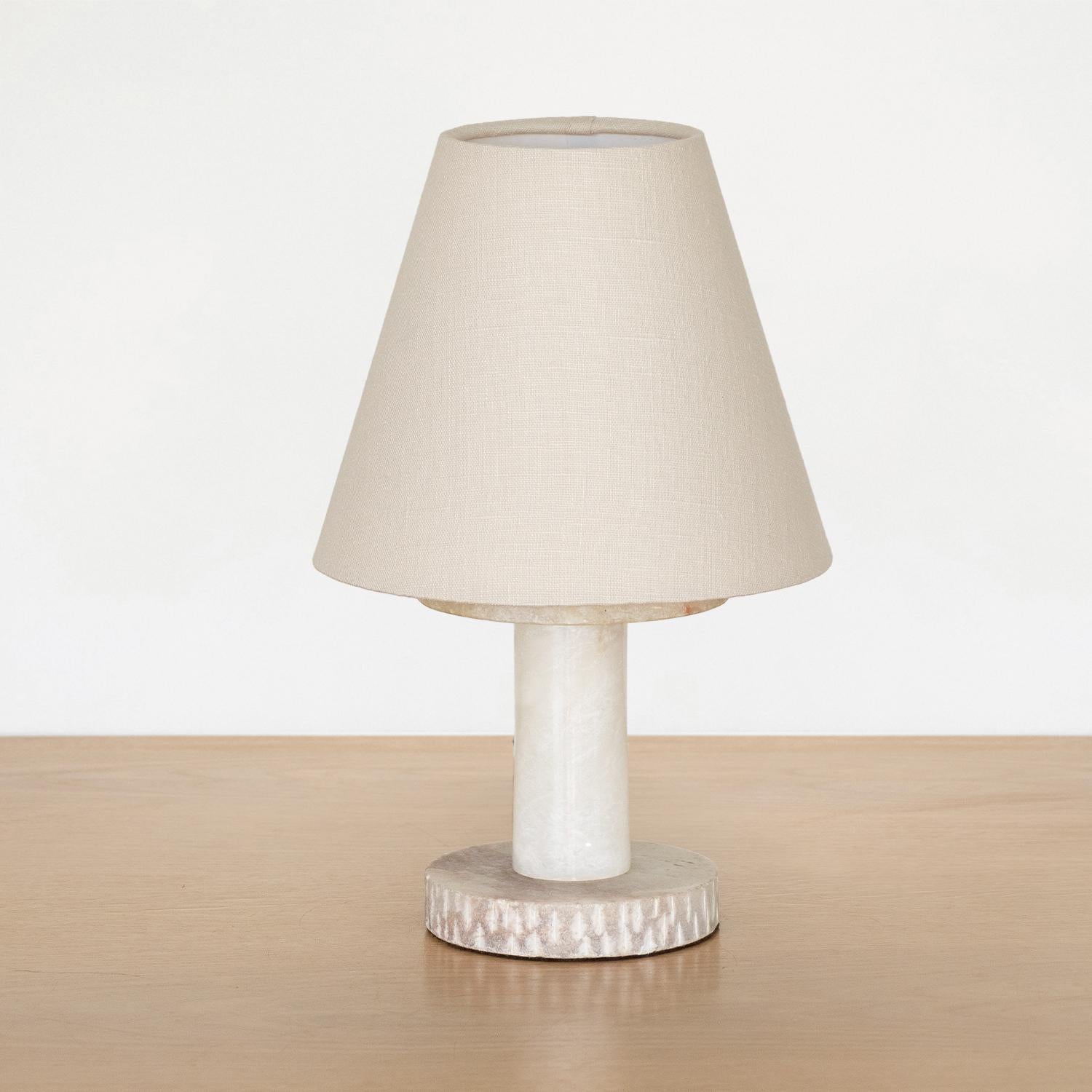 French white alabaster table lamp with solid carved base and new tapered linen shade. Modern shape with beautiful veins in stone. Newly rewired.