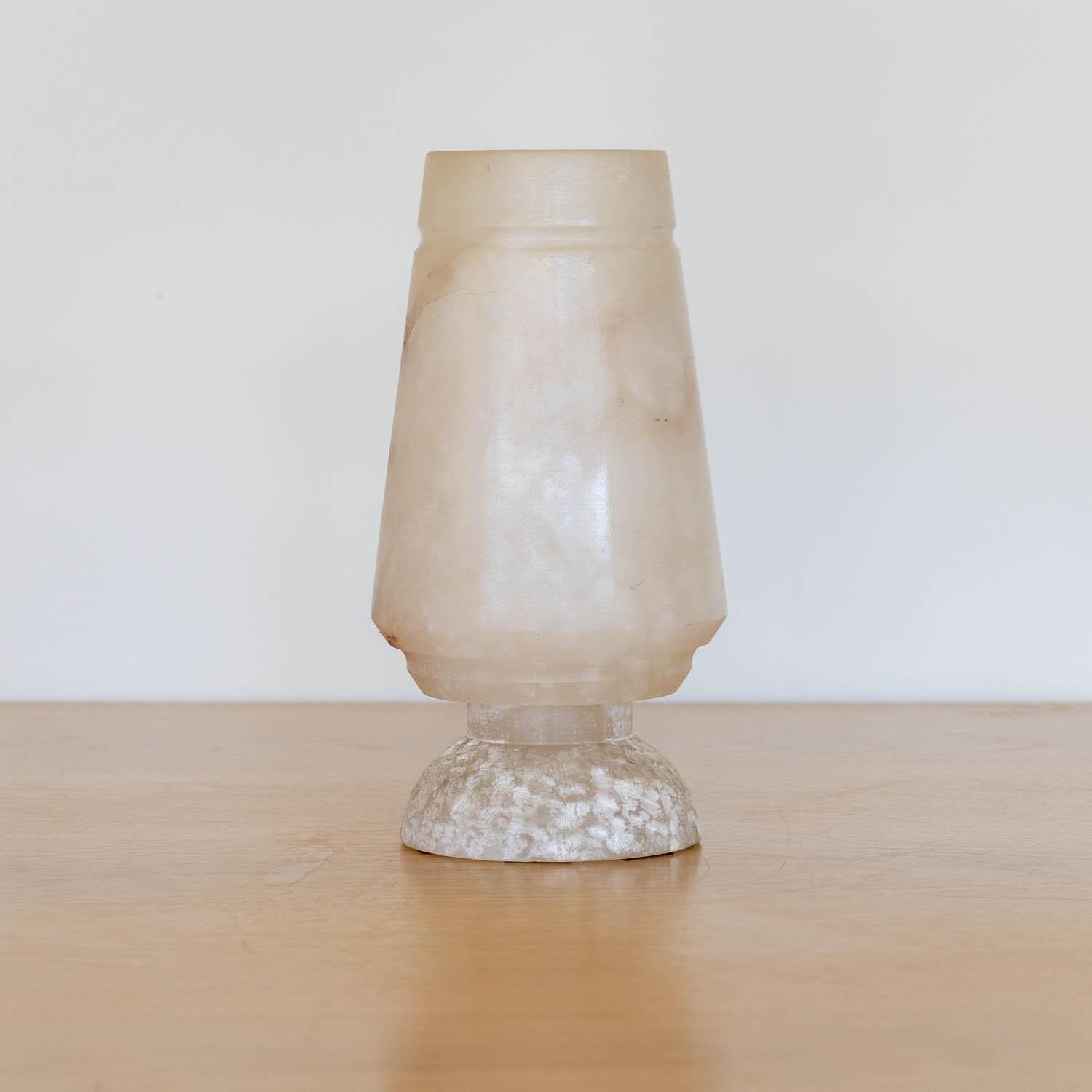 Beautiful alabaster table lamp from France, 1940's. Carved from a single piece of stone a tapered shade and etched dome base. Alabaster shows stunning veins and coloring. Vintage piece shows signs of age with some scuffs.  Newly re-wired. Takes one