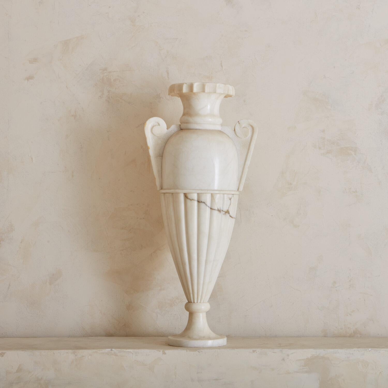 A unique carved alabaster urn shaped lamp. This lamp is 31”H and looks dramatic set on the floor or raised on a shelf or table. Sourced in Paris, France.