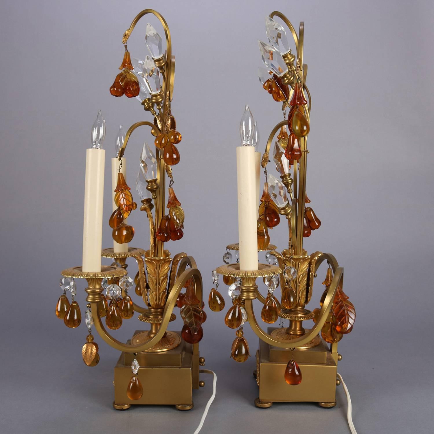 Pair of French two-light candelabra lamps feature gilt bronze foliate branch and leaf form gilt frame with amber glass and cut crystal prisms, each lamp with two candle lights, professionally rewired, circa 1930

Measure - 22