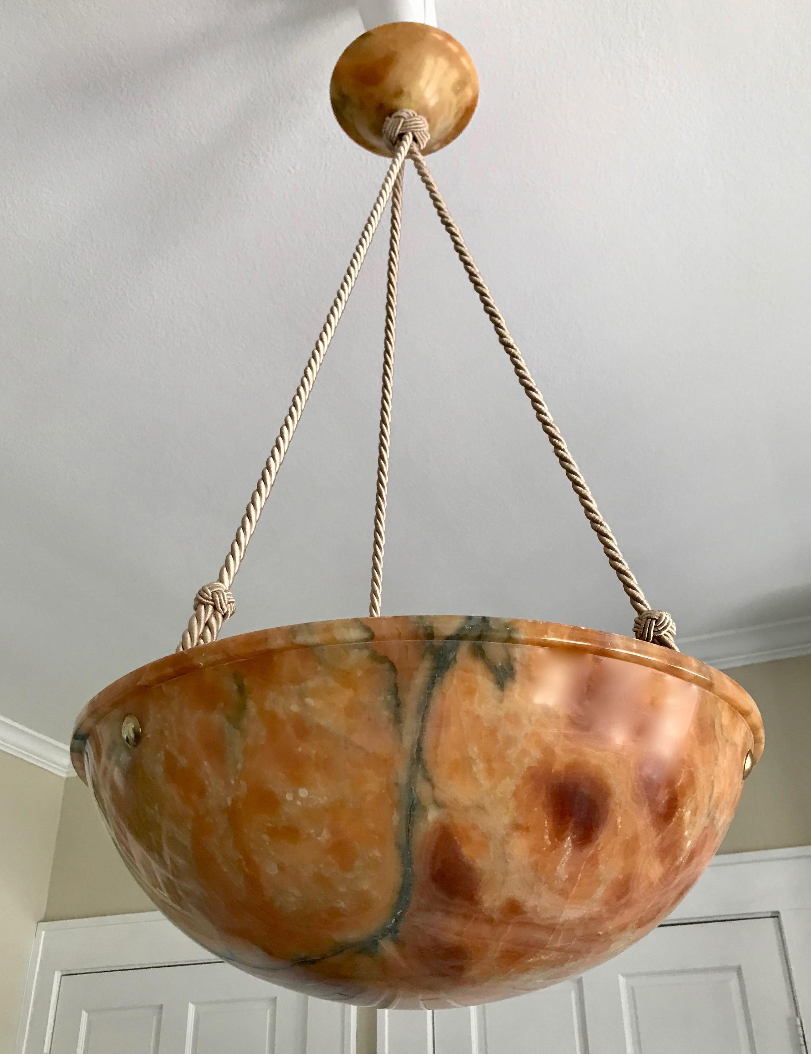 Stunning French alabaster pendant light or chandelier with exceptional figuring and movement in the amber or tortoise shell colored bowl. New custom interior fittings keep bulbs away from the alabaster and provide a more even light. Recently wired