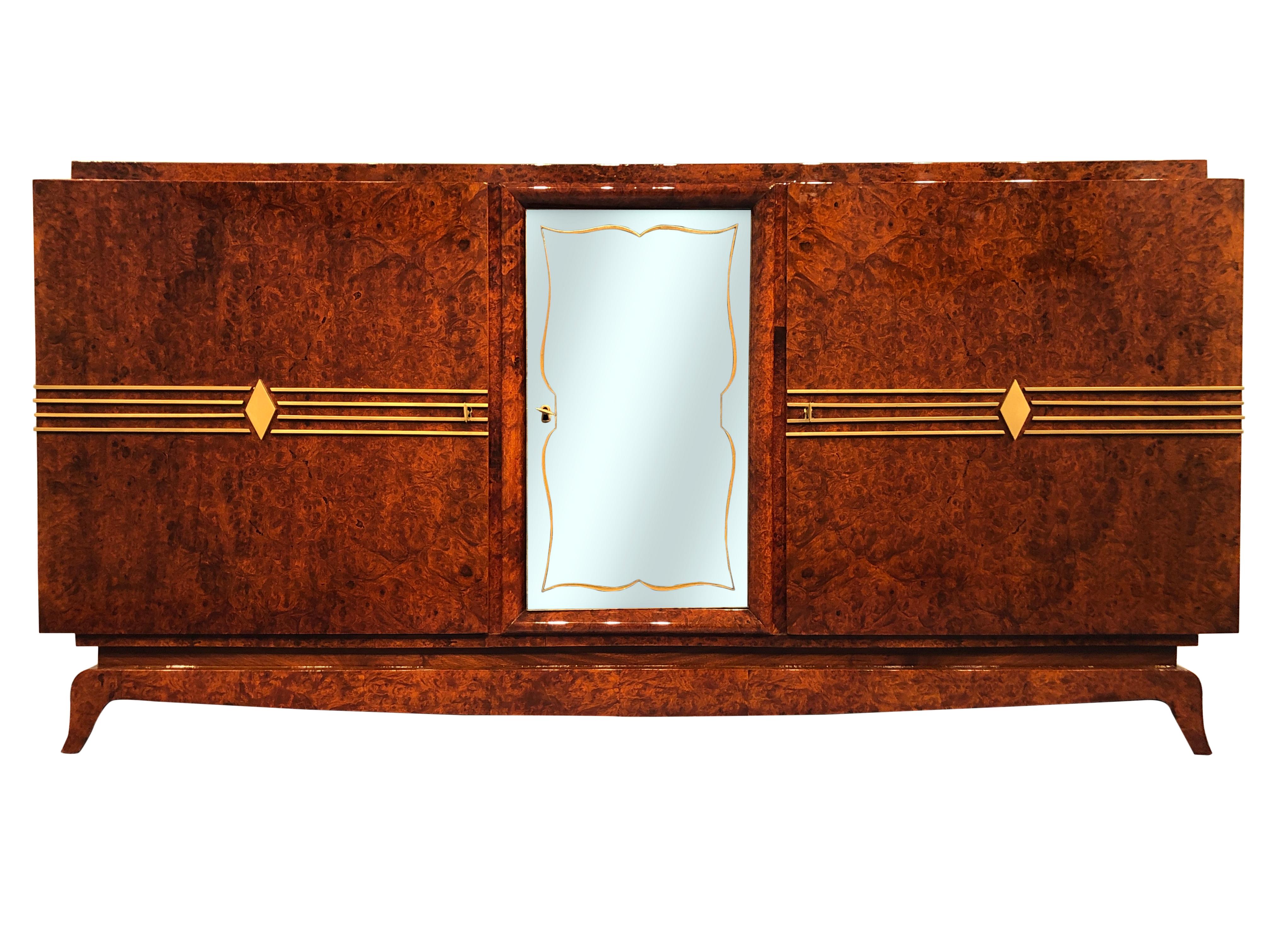 Elegant Art Deco sideboard in amboyna with precious golden inlays on the doors, 
the central door is in the glass with an inside drawer. Insides in elm.
Small marks on the mirror, if required can be replaced with a new one.
 