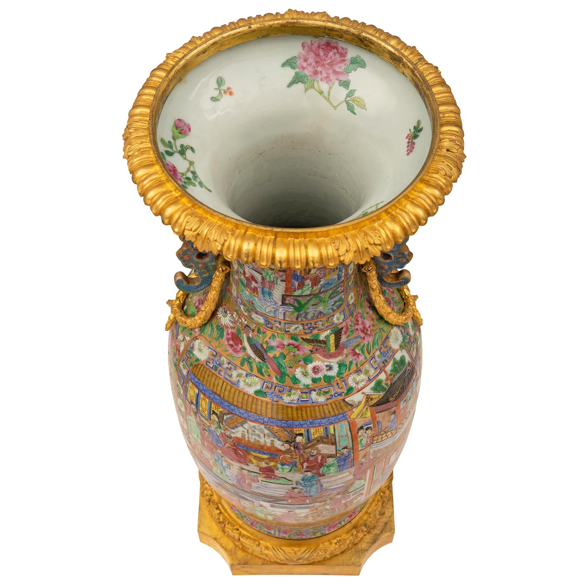 A beautiful and high quality French and Asian collaboration 19th century Louis XVI st. Famille Rose porcelain urn. The urn is raised by a fine square ormolu base with concave corners and a richly chased wrap around tied berried laurel band. The