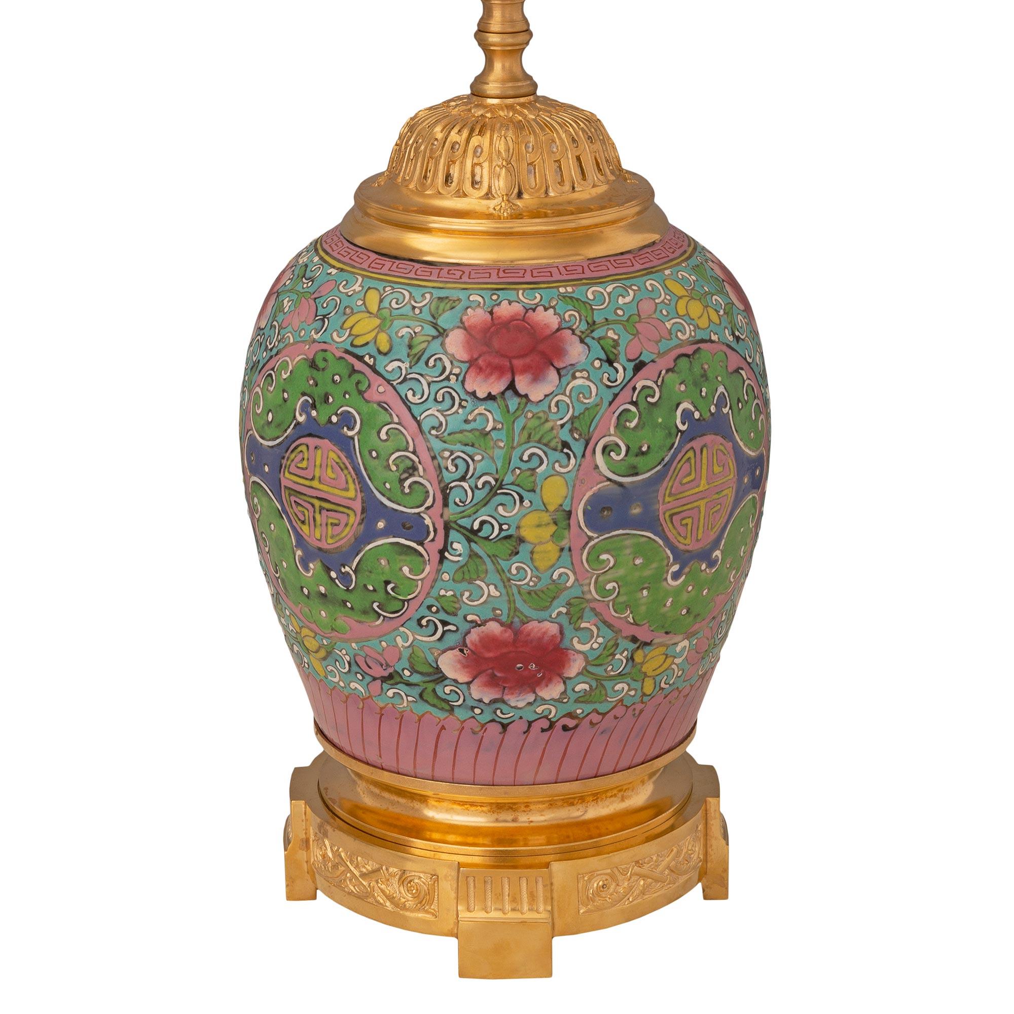A beautiful French and Asian collaboration 19th century Louis XVI st. Belle Époque period Famille Rose porcelain and ormolu lamp. The lamp is raised by an elegant circular mottled ormolu base with fine fluted block feet and lovely fitted scrolled