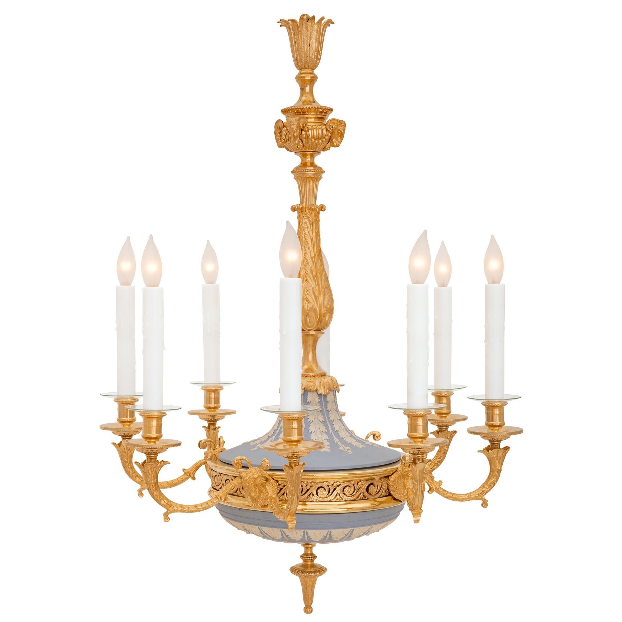 A stunning and extremely decorative French and English collaboration 19th century Louis XVI st. Belle Époque period ormolu and Wedgwood porcelain chandelier. The eight arm chandelier is centered by a most elegant foliate topie shaped bottom finial