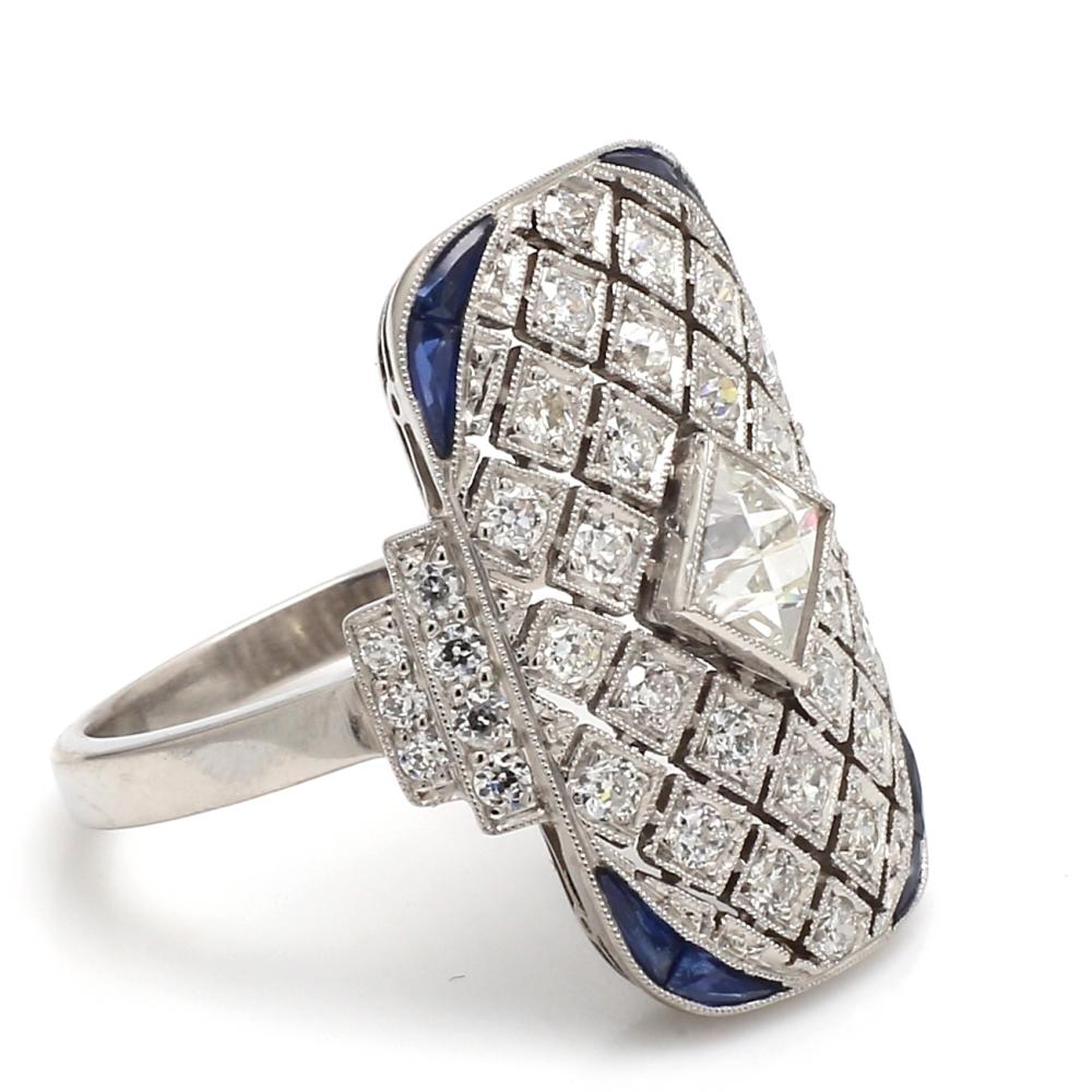Platinum Ring with White Diamonds and Blue Sapphires

This striking ring features a central white diamond, expertly set to maximize its brilliance. Surrounding the primary stone are additional white diamonds, arranged in an intricate lattice