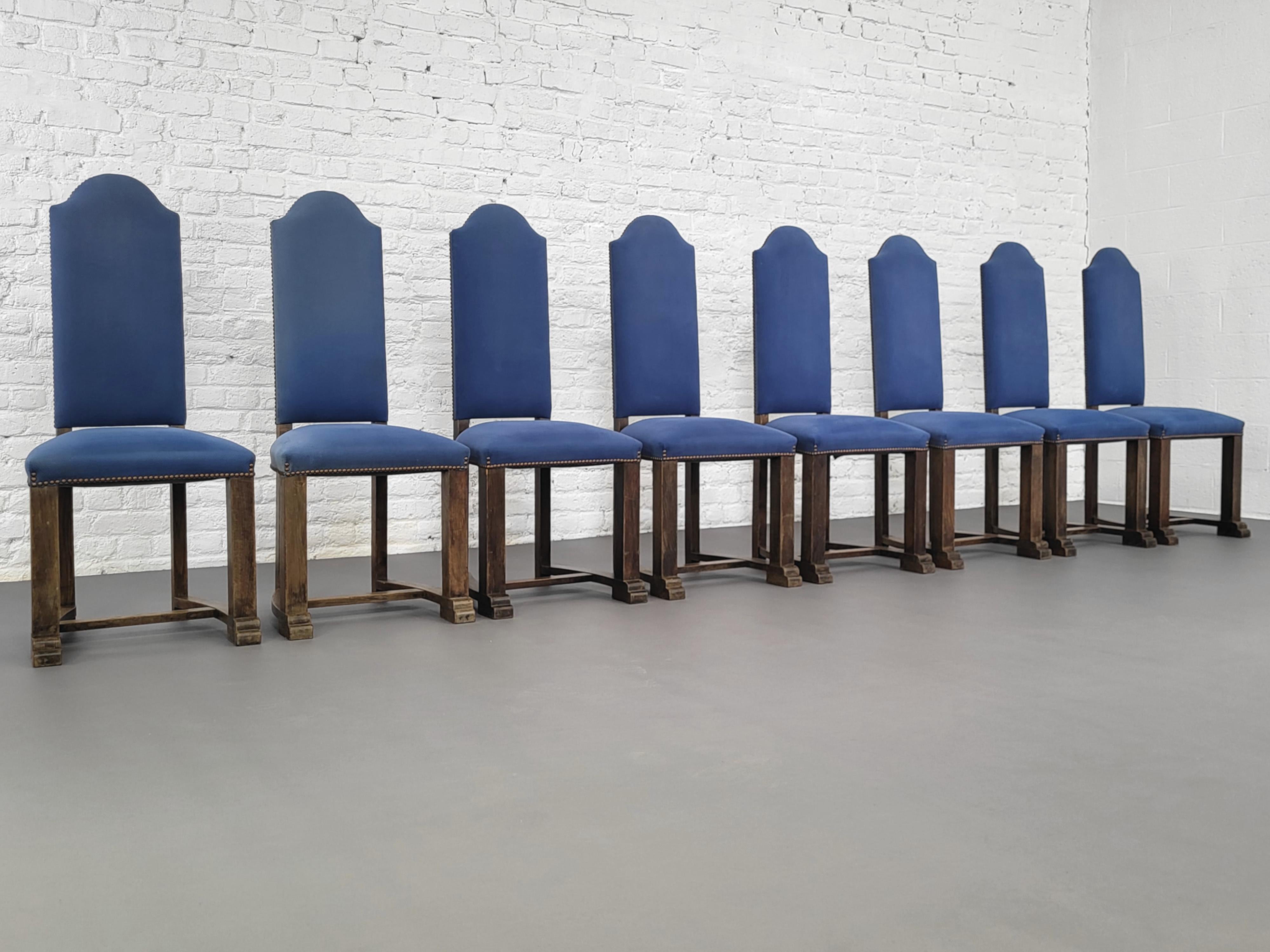 French Antic Louis XIII Style Wooden And Fabric Set of 8 Chairs composed of a curved and sculpted wooden high back structure adorned with blue fabric.