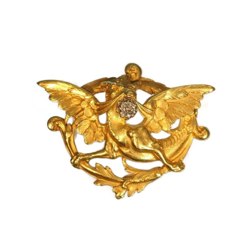 A fine French antique brooch depicting a griffin in 18 karat yellow gold, French control mark, set with a center old European cut diamond .15 carat (color and clarity grade: G/H, si/i). Dimensions: 1.59 inch x 1.22 inch. Weight 14.40 gram.