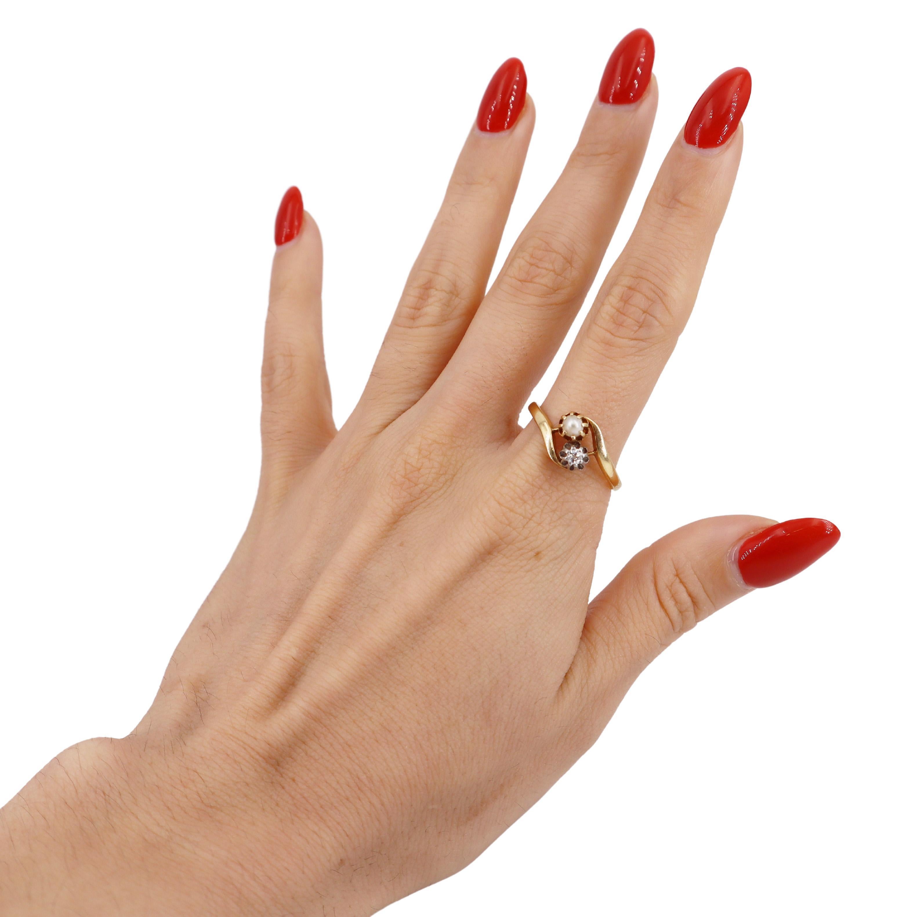 Dieser bezaubernde antike französische Ring aus 18-karätigem Gelbgold präsentiert in seiner Mitte eine schimmernde Perle, die durch funkelnde Diamanten von insgesamt ca. 0,08 Karat elegant ergänzt wird. Das Design des Rings spiegelt die für