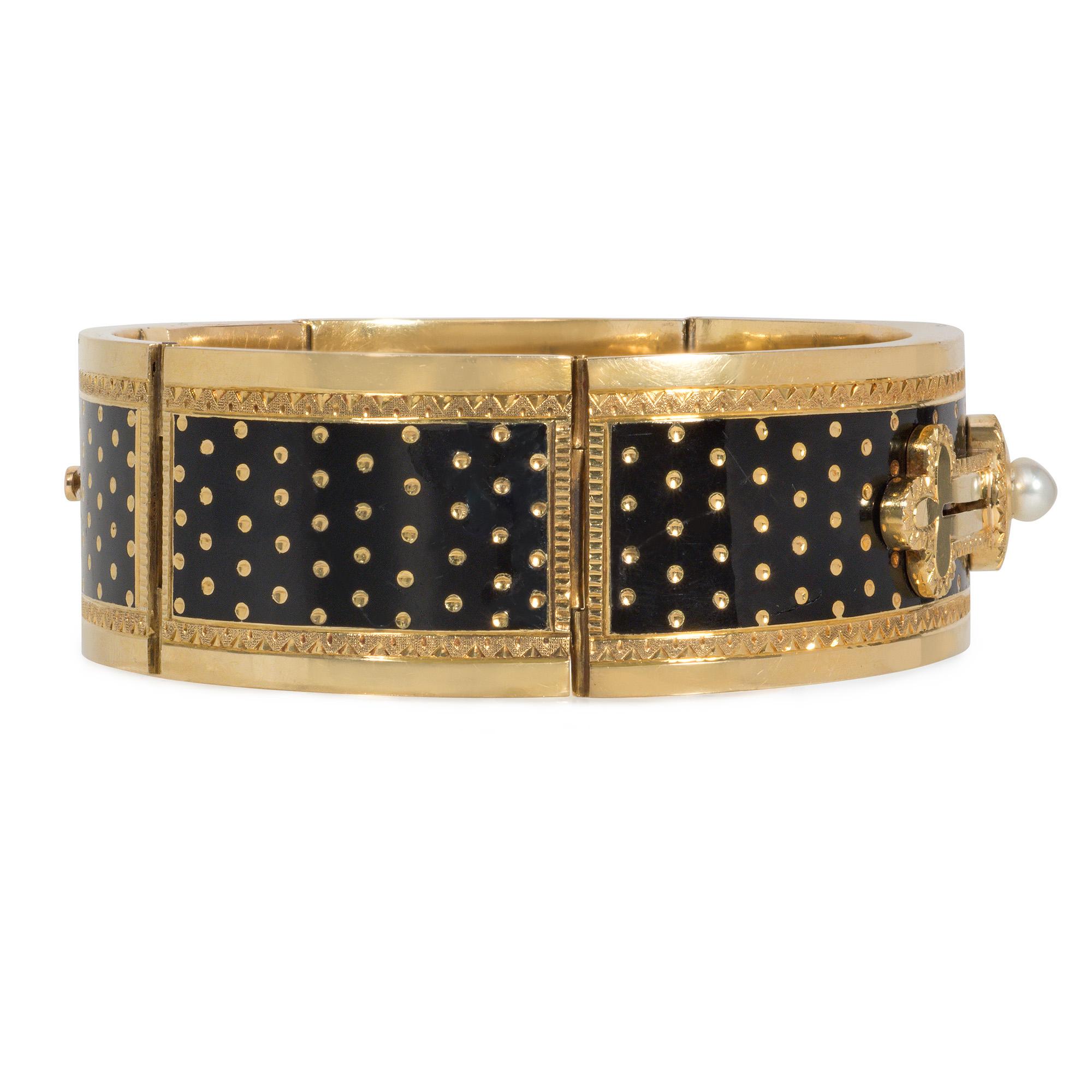 Antico braccialetto a cerniera in oro e smalto di epoca vittoriana con smalto nero e decorazioni a pois, disegnato come un bracciale abbottonato con una perla, in 18 carati. Francia

Dimensioni: Circonferenza interna di 7 1/2