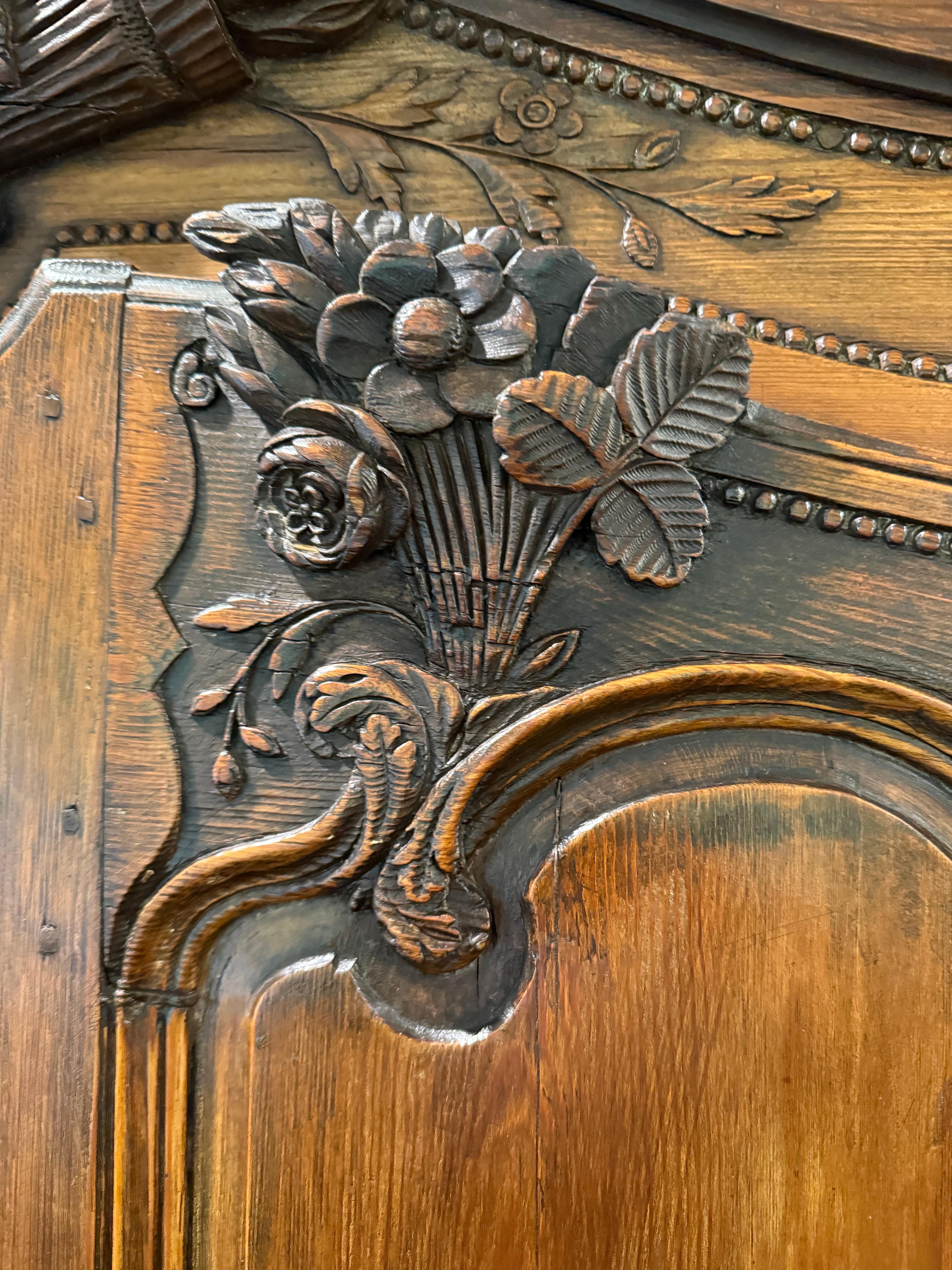 Eccezionale armadio in noce intagliato, un esempio di artigianato dei primi del XIX secolo.
Caratteristiche:
	-	Cornice Chapeau de Gendarme: L'armadio è coronato da una splendida cornice ad arco en chapeau, un segno distintivo del periodo Luigi XV,