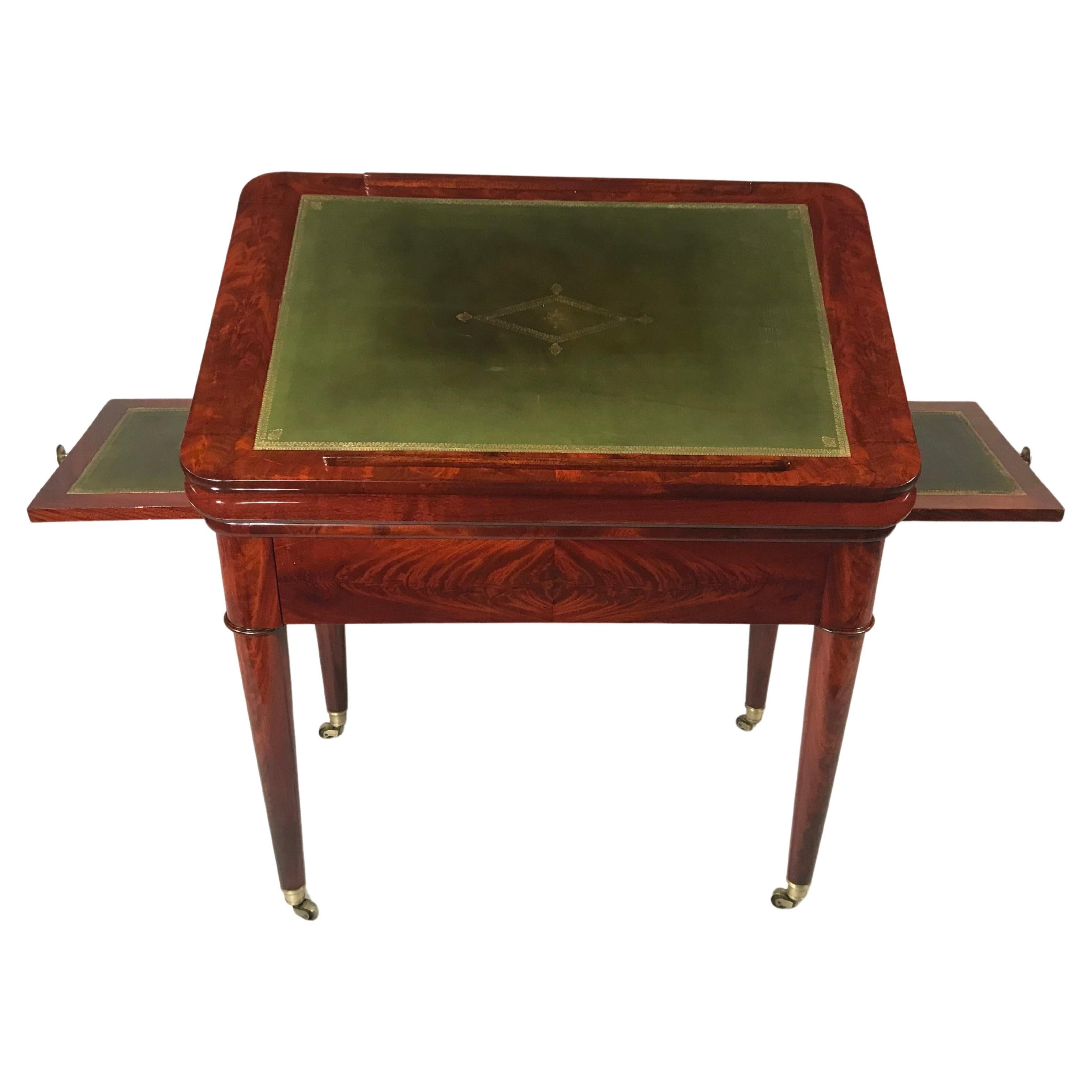 Explore a stunning late eighteenth-century Directoire Period architect’s desk crafted from figured mahogany. This exquisite piece features an adjustable green leather-lined writing surface with a hidden double rising system. Flanked by a pair of