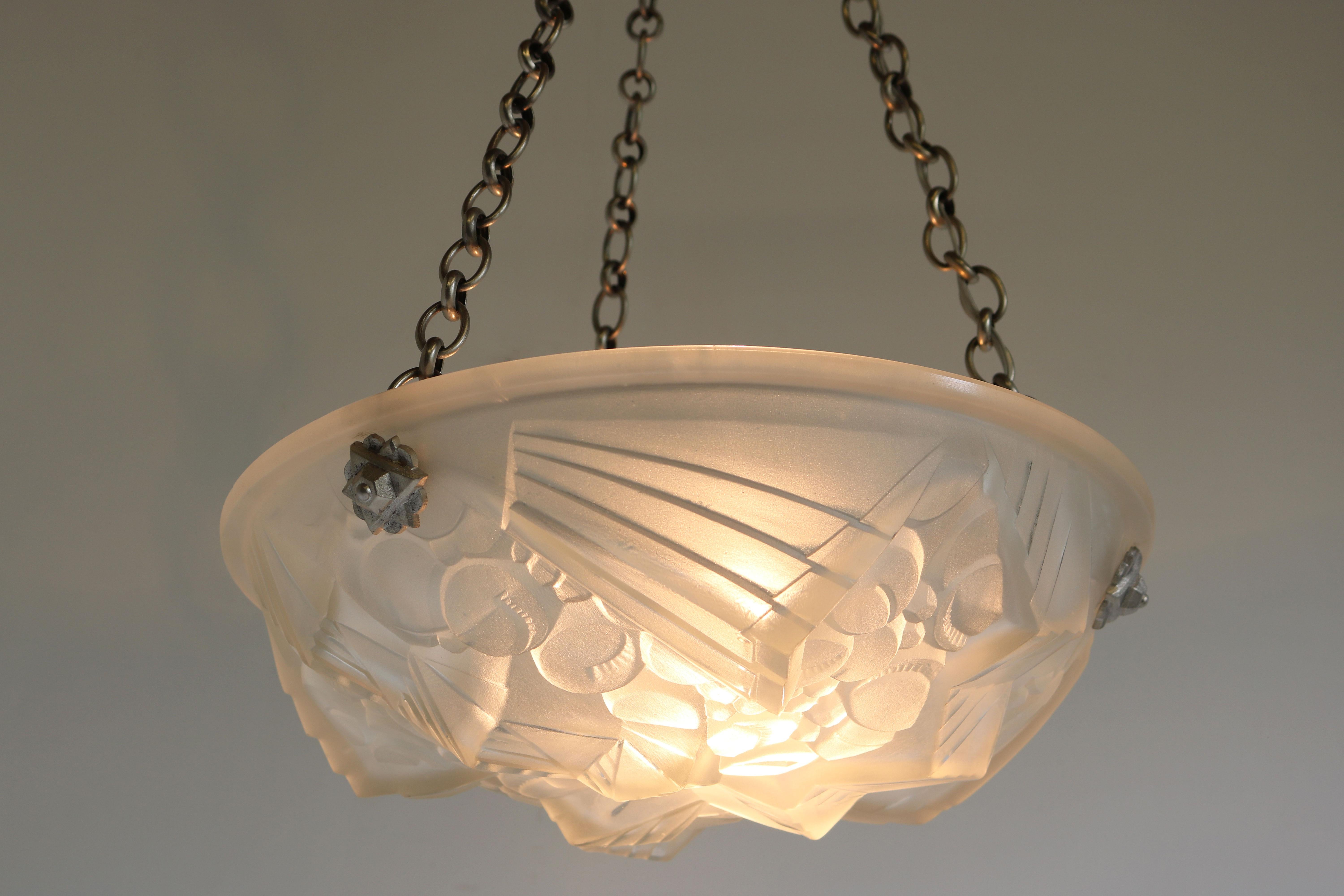 Amazing French Art Deco pendant chandelier by Mouynet (Paris), France, late 1920s. 
White frosted glass shade with a stunning Geometric Art Deco pattern. 
 The frosted shade has been hand cut to display a gorgeous scenery when lit , the light