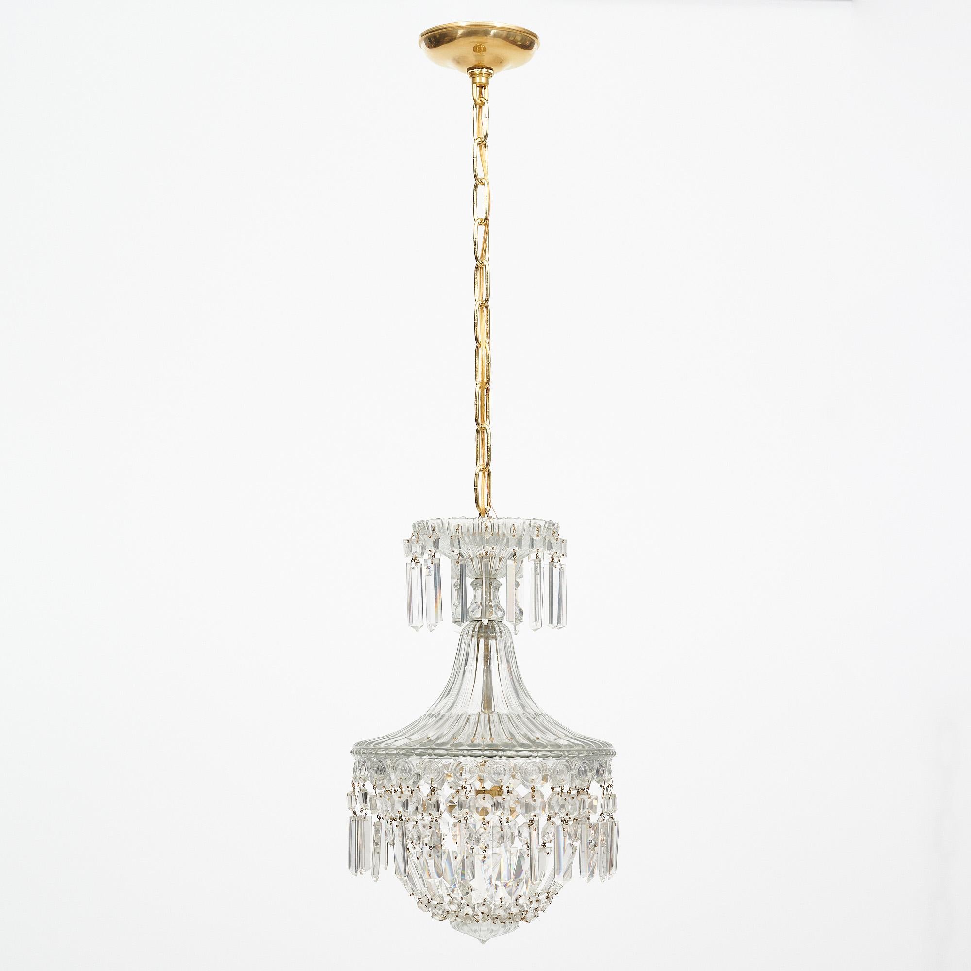 Antique chandelier from France by Baccarat. This beautiful fixture has a bell-shaped design all made of cut crystal elements (cabochons) that come together with a glass finial. There is a beautiful glass top and dripping crystal details throughout.