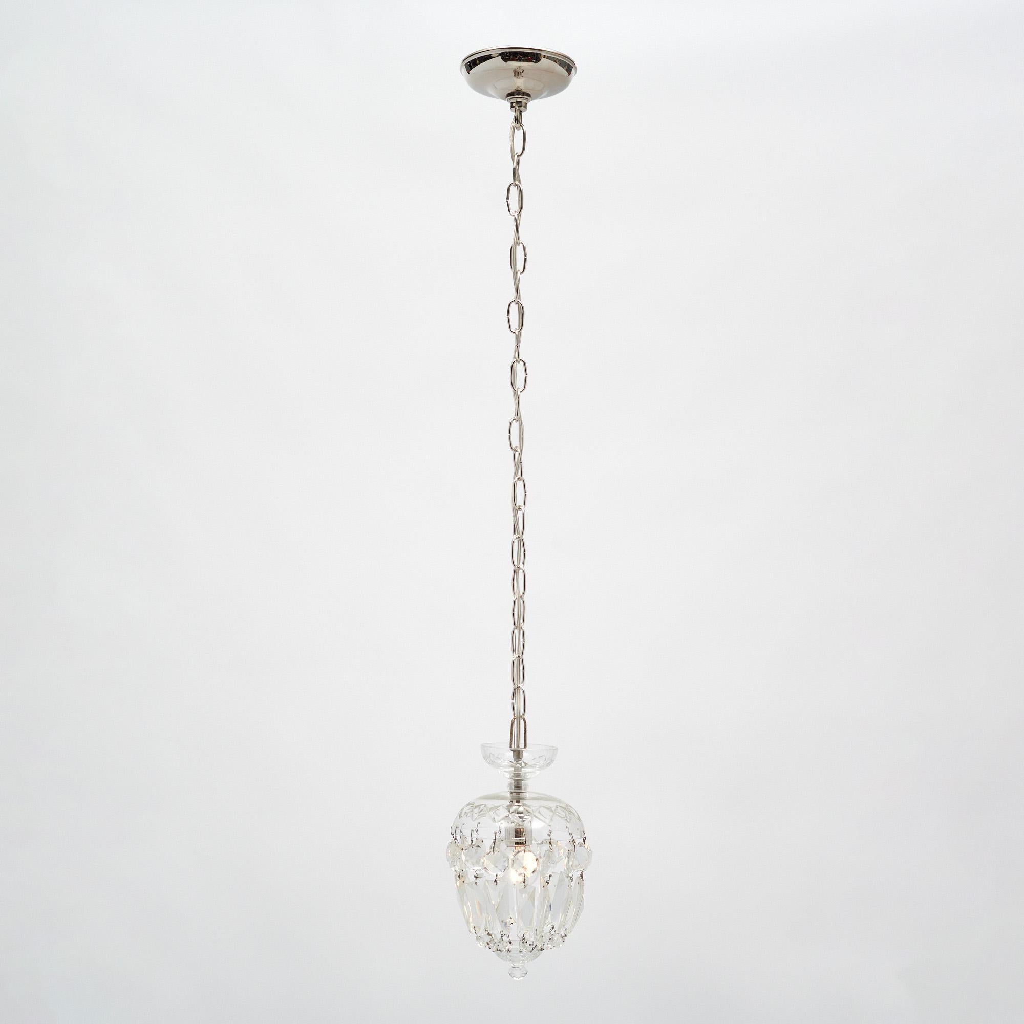 French pendant fixtures by Baccarat. The fixtures feature a hand engraved bell to which are attached to an array of cut crystal cabochons coming together at their bottom to a crystal finial. These fixtures have been rewired to fit US standards and