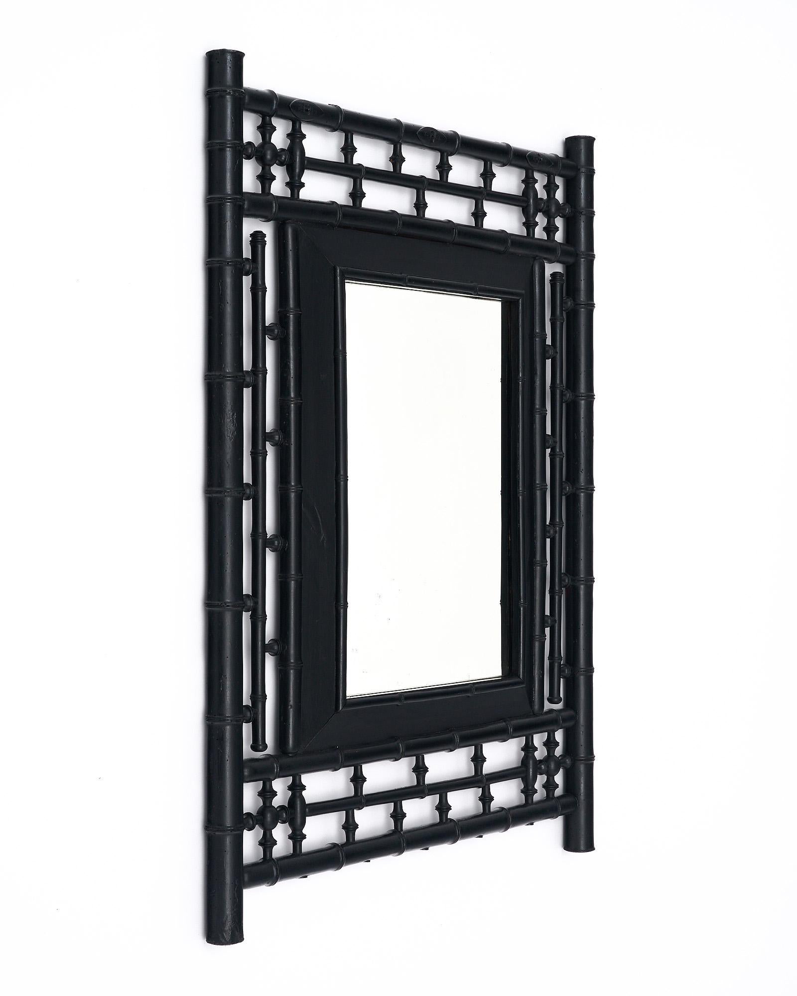 Miroir de France fabriqué avec un cadre structuré en bambou. Le cadre est orné d'éléments 