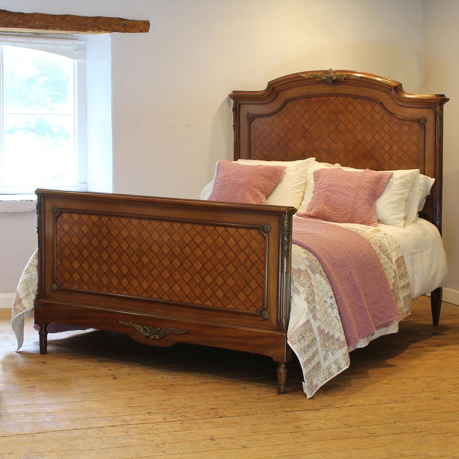 An attractive French antique bed with inlaid fruitwood parquetry panels, elegant shape and ormolu decoration.

This bed accepts a US Queen Size (or UK King Size), 5ft wide (60 in), base and mattress set.

The price includes a firm bed base for the