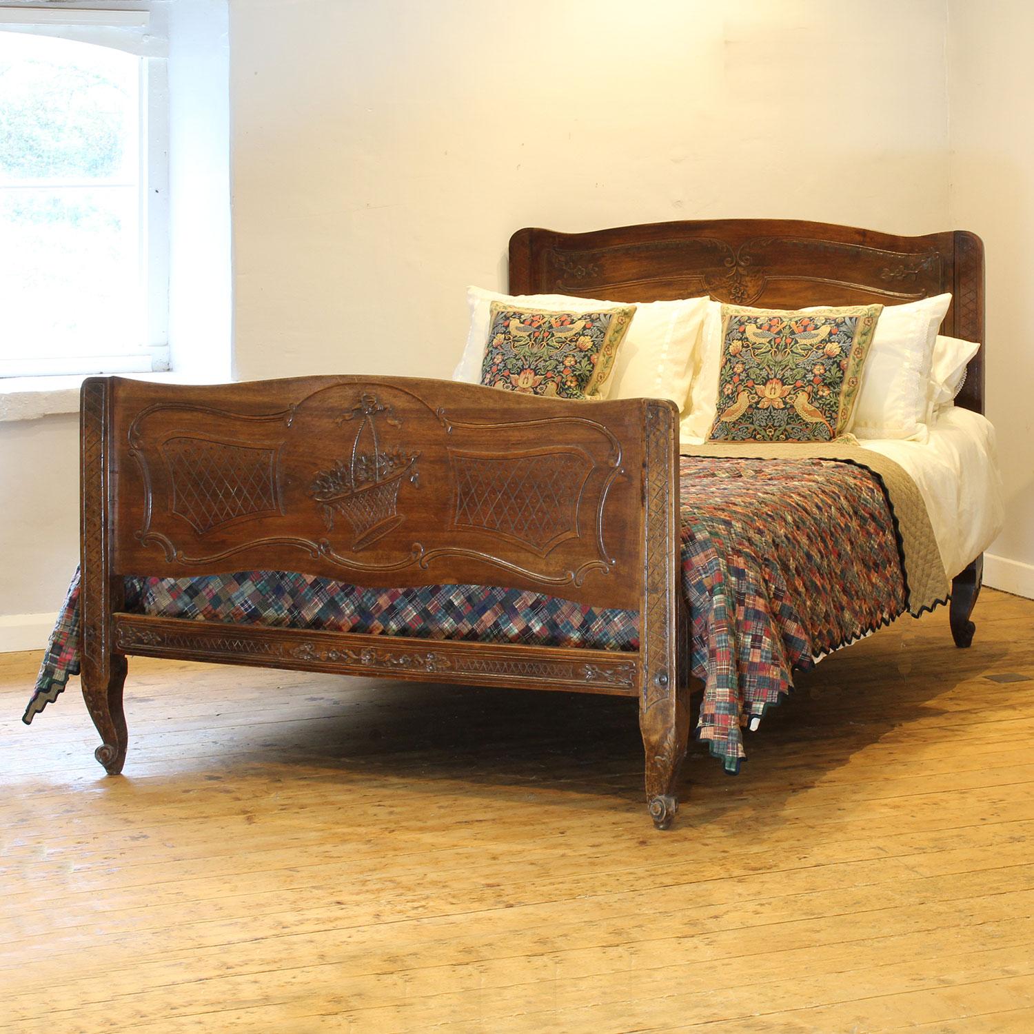 A rural French antique bed in walnut with delicate carving and shaped legs.

This bed accepts a British king size or American queen size, 5ft wide (60 inches or 150cm) base and mattress set, with an overlap (as shown)

The price includes a deep
