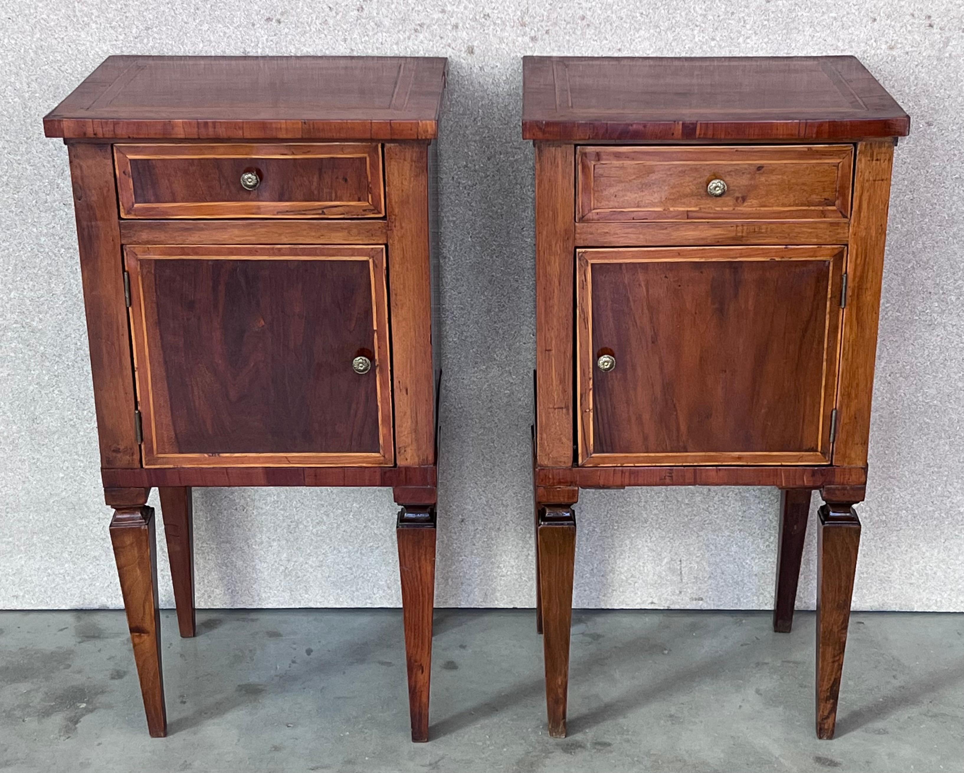 A 18th century French Louis XVI style marquetry side table, or nightstand, with a marquetry top. One dovetailed drawer above cabinet doors. Made of inlaid veneer of various woods, mainly mahogany. Slender legs. In excellent condition with only minor