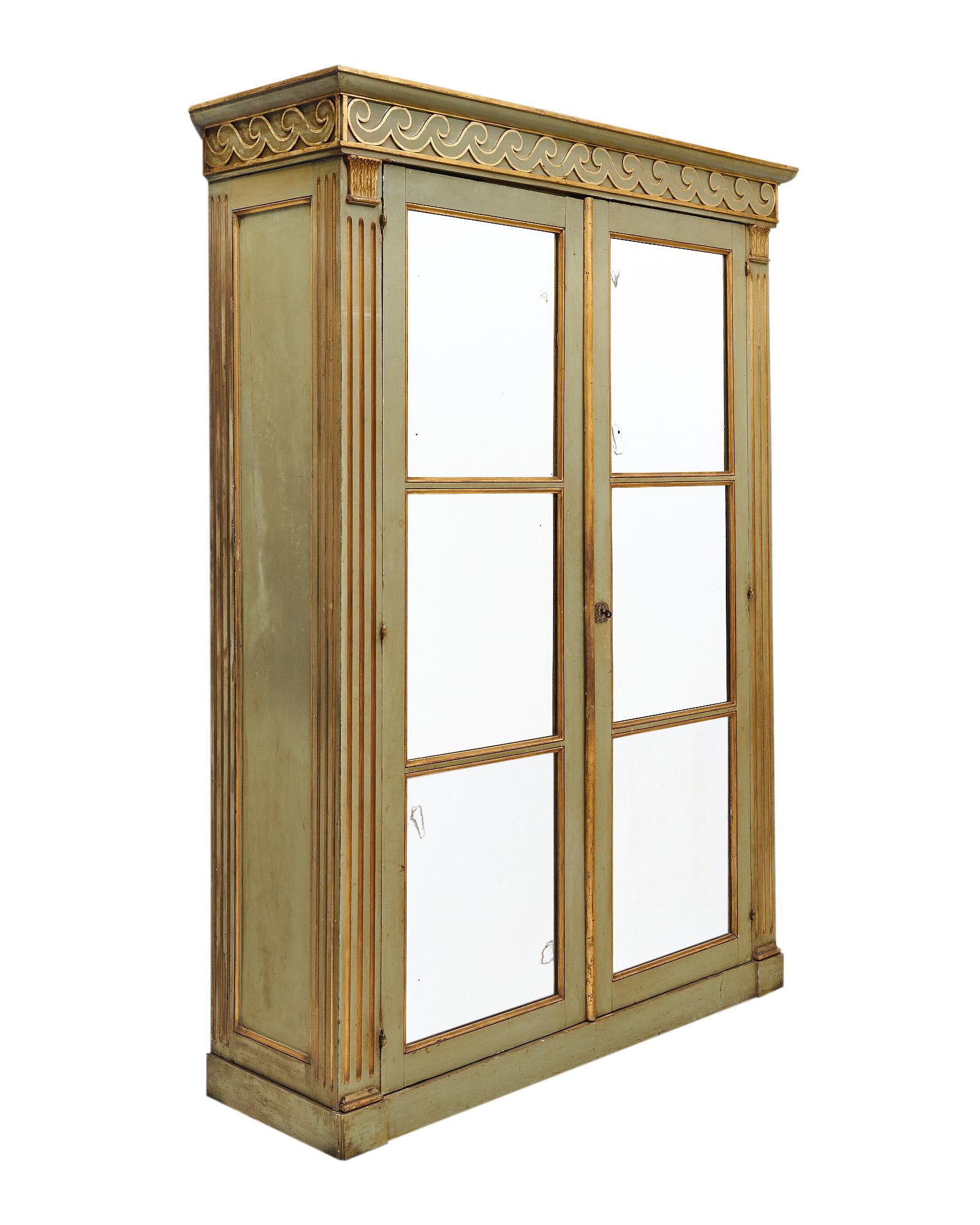 Bookcase from France made of solid wood construction that has been finished with an original green paint. The front of the bookcase is adorned with hand carved columns and a frieze of stylized waves and acanthus leaves in a very pure Etruscan style.