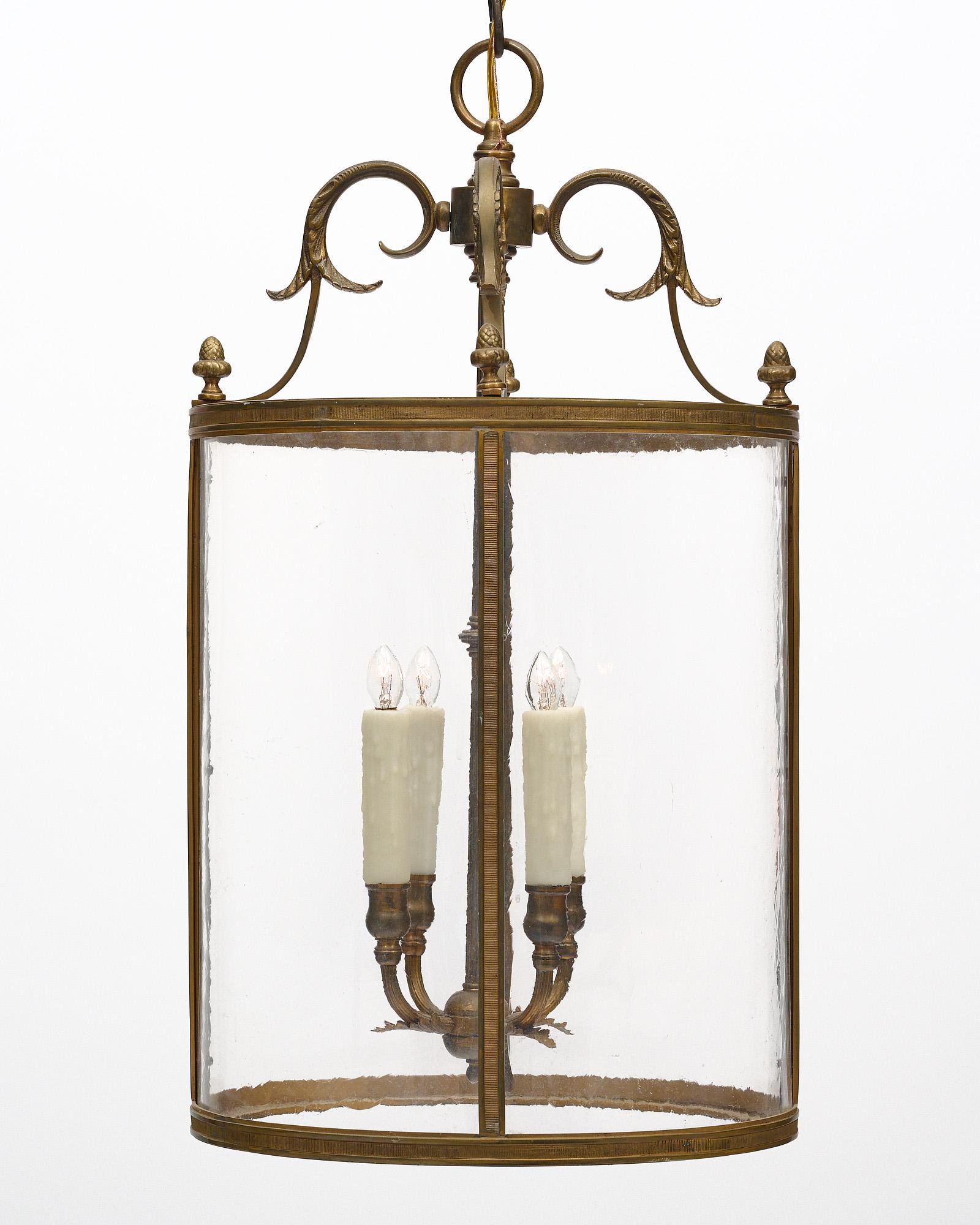 Lantern from France with a bronze structure and curved glass panes. The fixture is adorned with stylized acorn finials and acanthus leaves. There are four candelabras. It has been newly wired to fit US standards.
The current overall height from