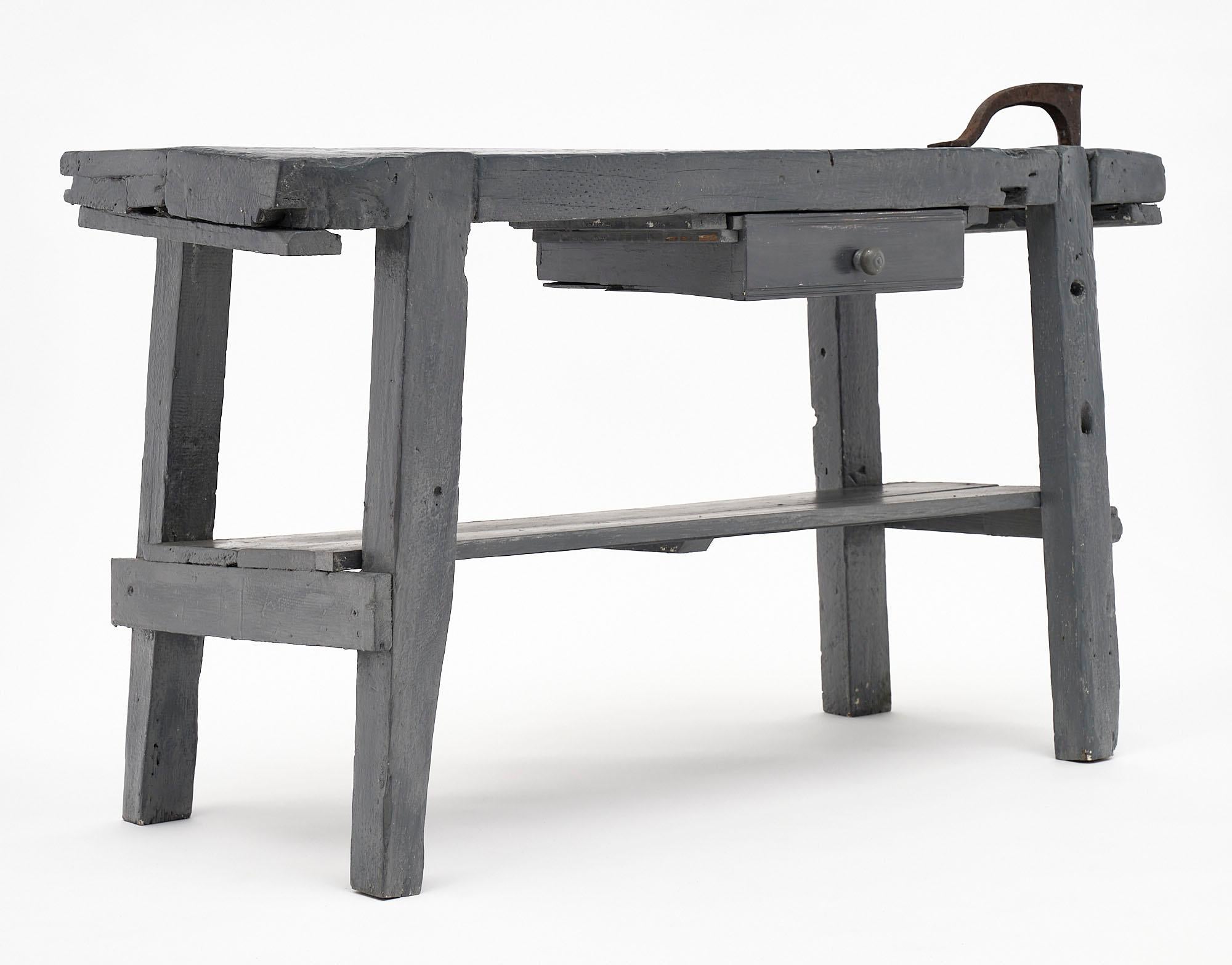 French antique carpenter’s workbench from the Alps. This piece is made of painted chestnut and features a drawer and a cast iron hand vise.