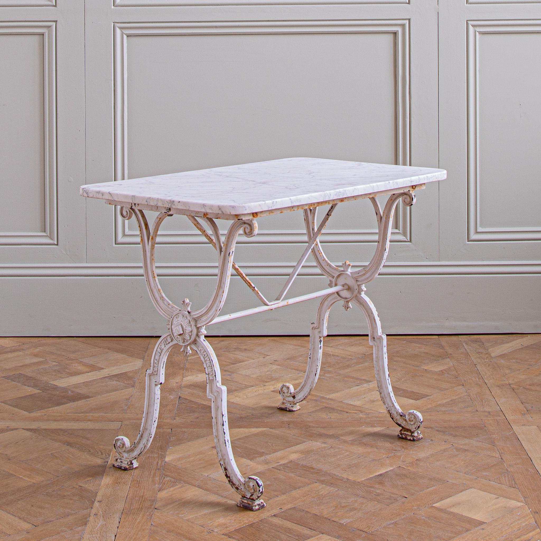 A French bistro table which can be used indoors or outs - as a garden table. The base is in a classical, French, early 1900's style and is made in cast iron by Clermont Fils of Perpignan. The base has its original white paintwork which has some