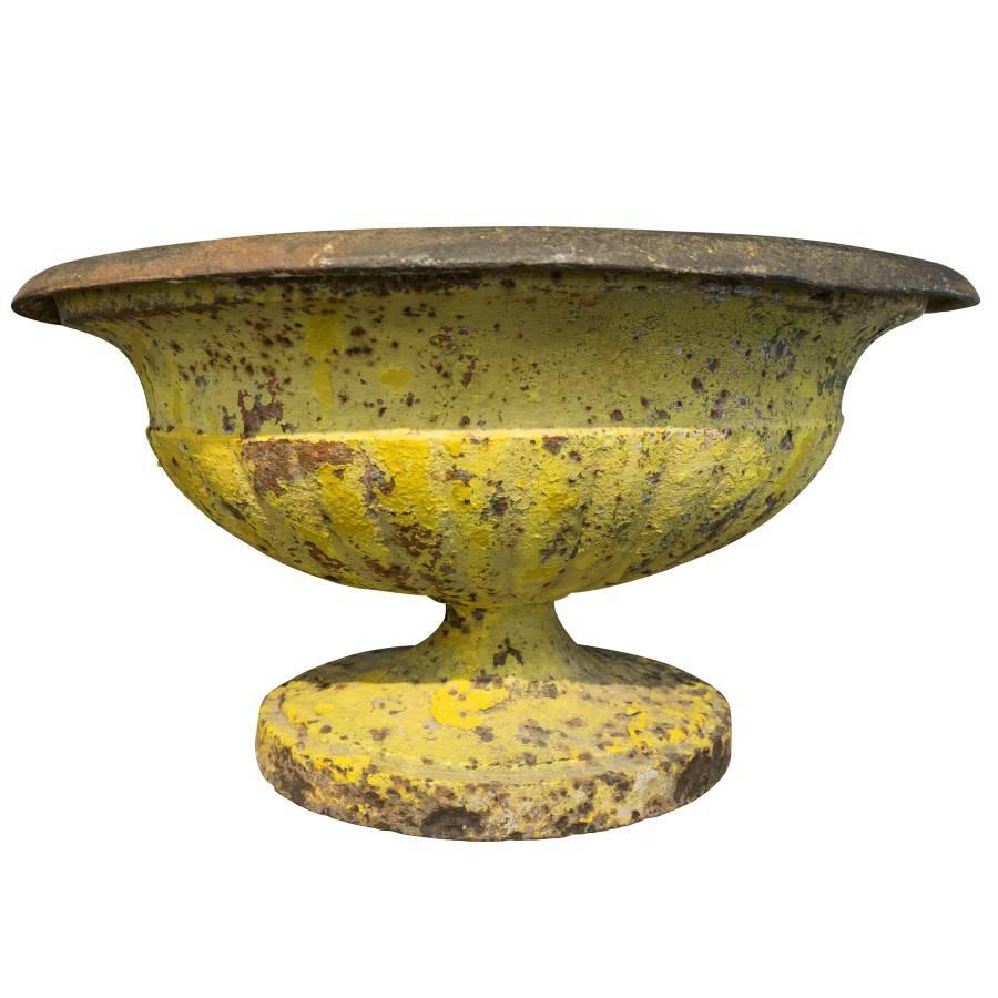 Created in France, circa 1890, this heavy classical urn has a bright coat of yellow paint, and is well aged allowing for the patina of rust and wear to add texture and character. A French garden antique that embodies a lineage of craftsmanship, and